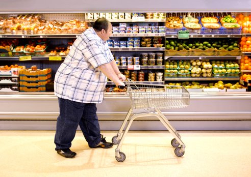 Photo of overweight man passing by healthy food in supermarket | Photo: Getty Images