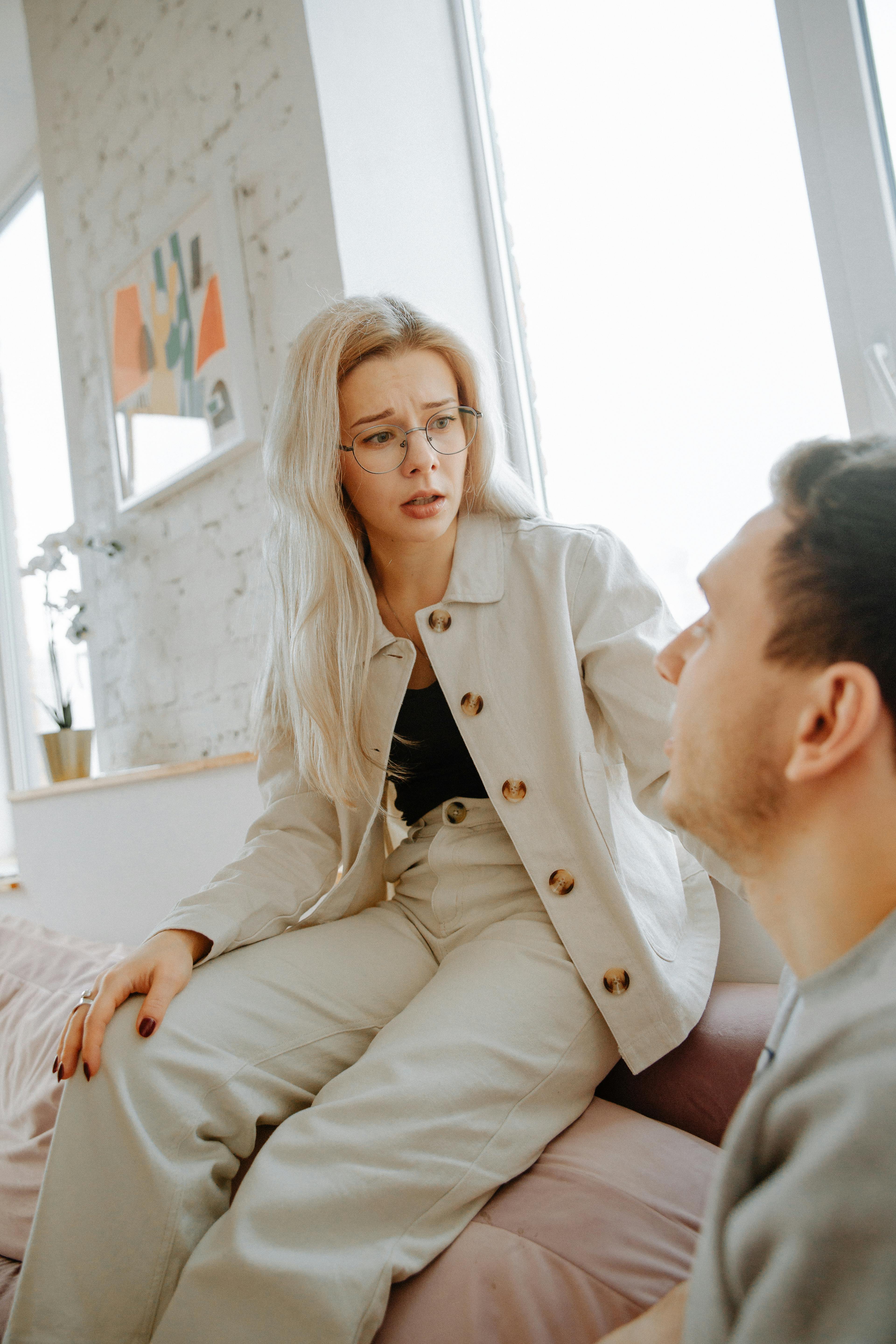 A worried woman talking to a man at home | Source: Pexels