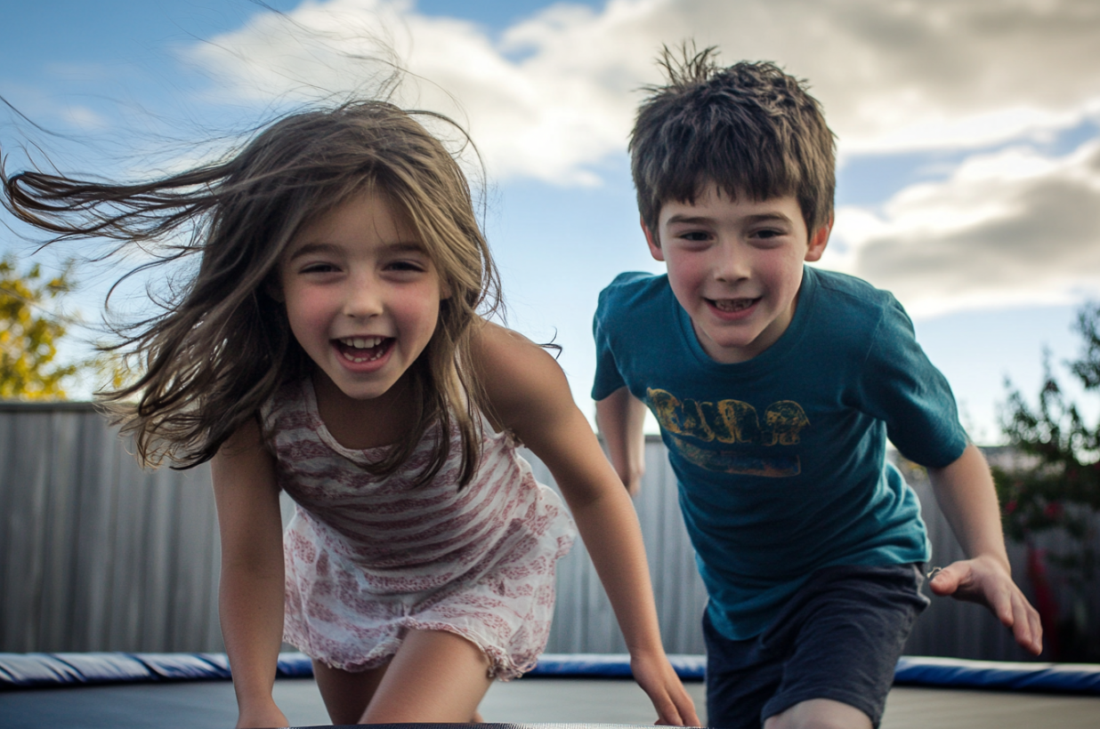 Two kids playing on a trampoline | Source: Midjourney