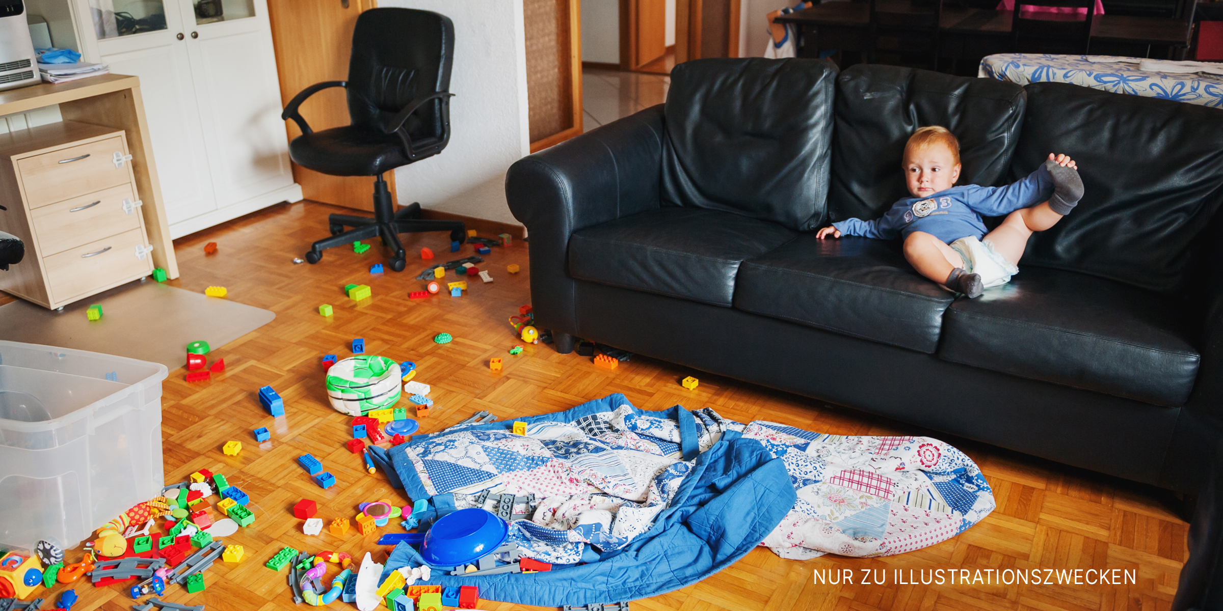 Baby liegt auf einer Couch in einem unordentlichen Zimmer | Quelle: Shutterstock