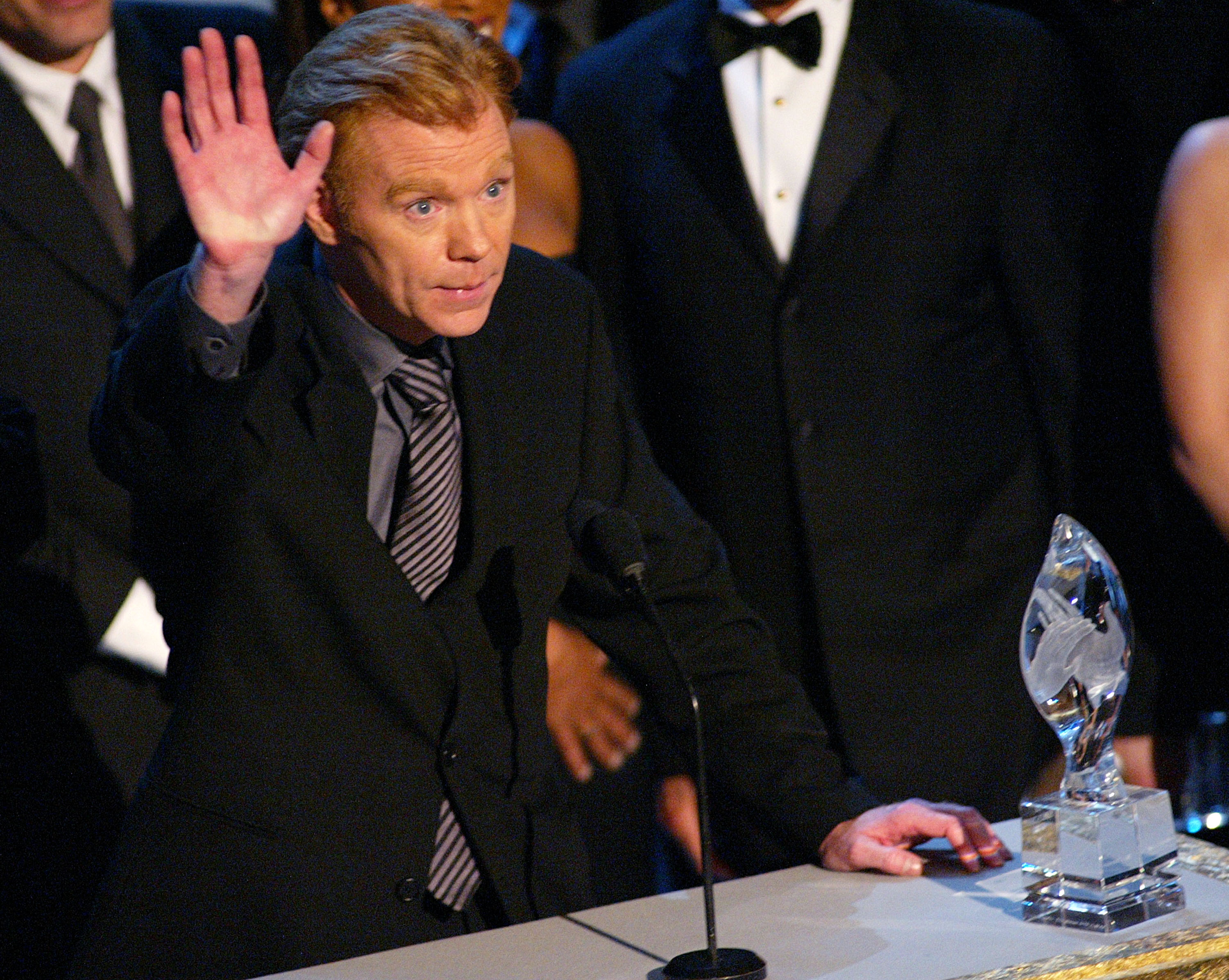 David Caruso waves from the stage at the 29th People's Choice Awards in Pasadena, California, where he accepted Favorite New TV Dramatic Series for "CSI: Miami."