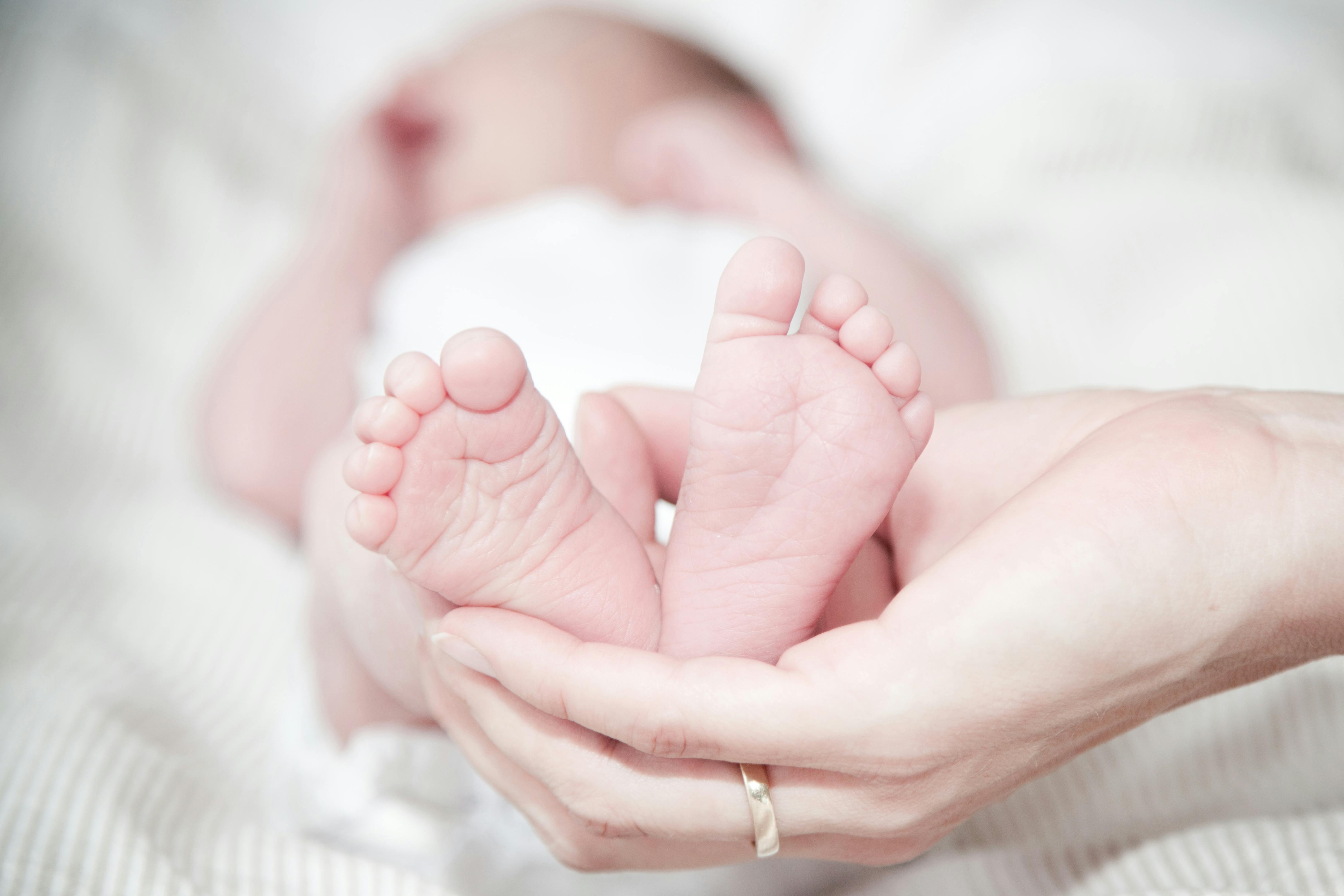 A woman holding her newborn baby's feet | Source: Pexels