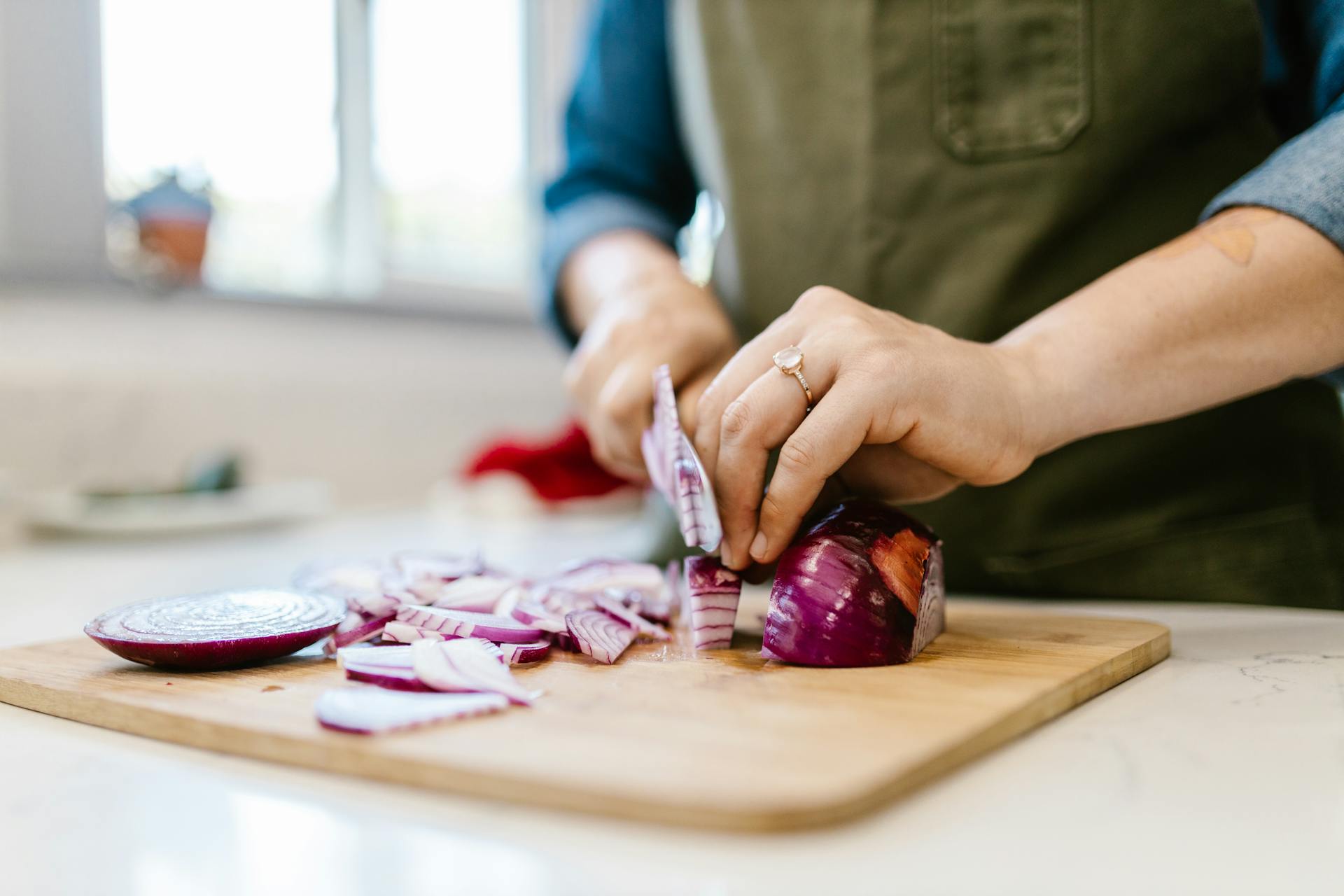 A closeup of a woman chopping onions | Source: Pexels