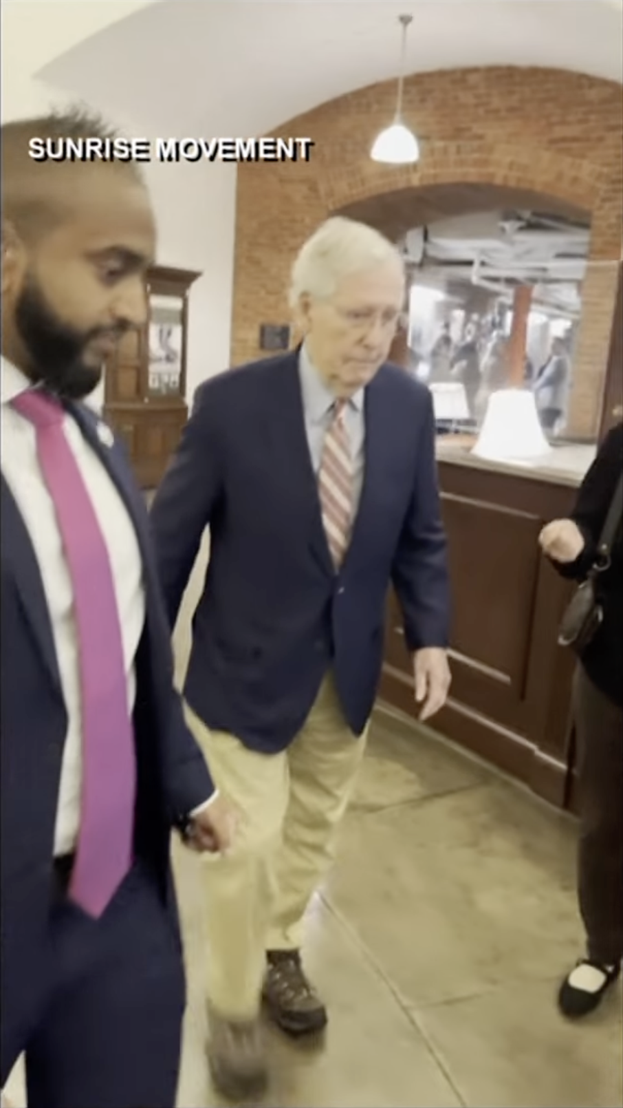 Senator Mitch McConnell walks through the Capitol corridor accompanied by a staff aide, as posted on October 16, 2025 | Source: YouTube/WHAS11News