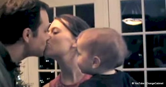 Cute baby feels jealous of father kissing mum and starts a 'kissing fight' with him