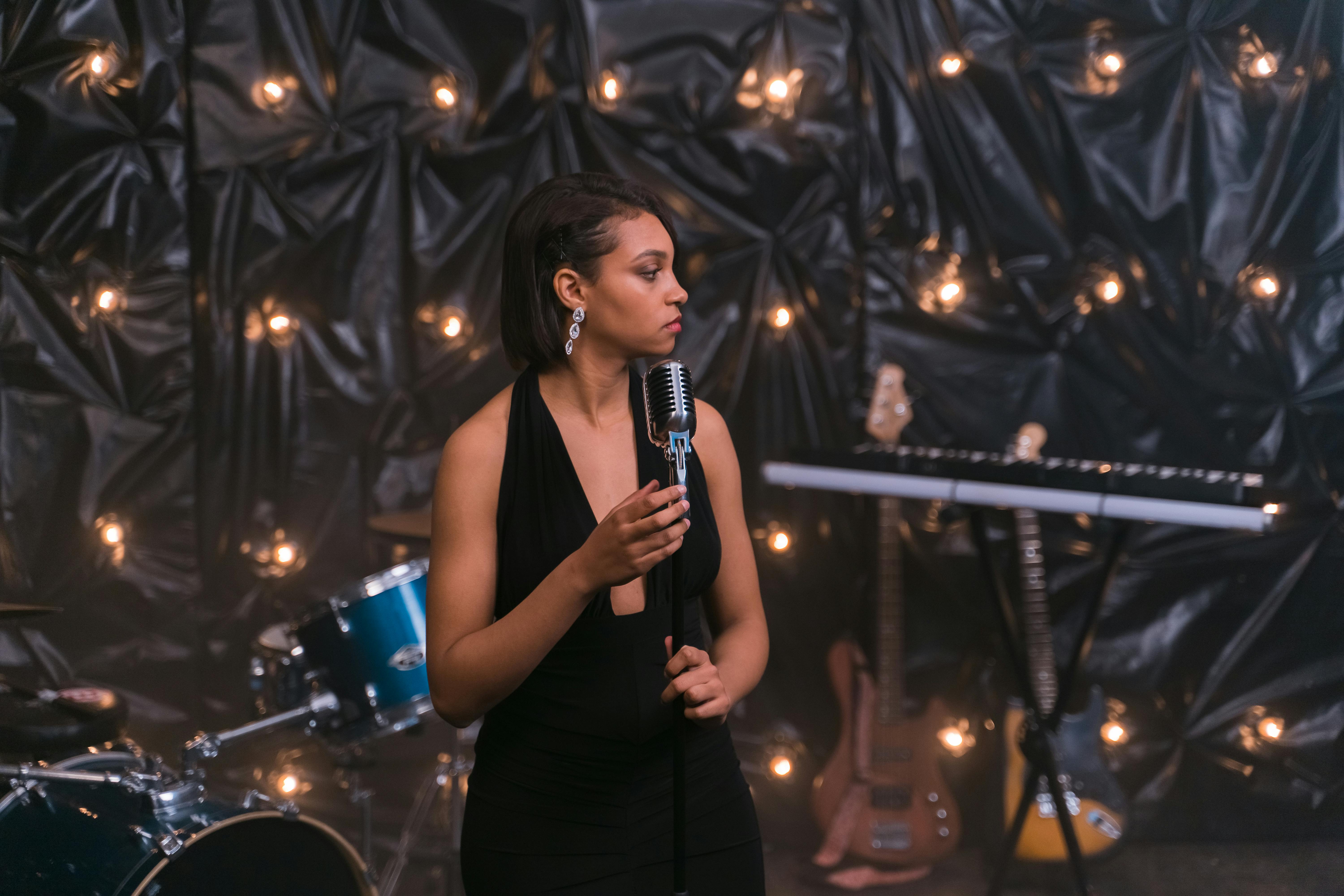 A woman speaking on a microphone on stage | Source: Pexels