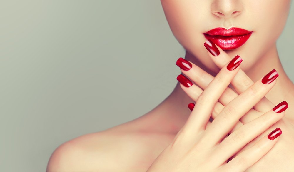 Mujer mostrando sus uñas pintadas con un esmalte rojo. | Foto: Shutterstock