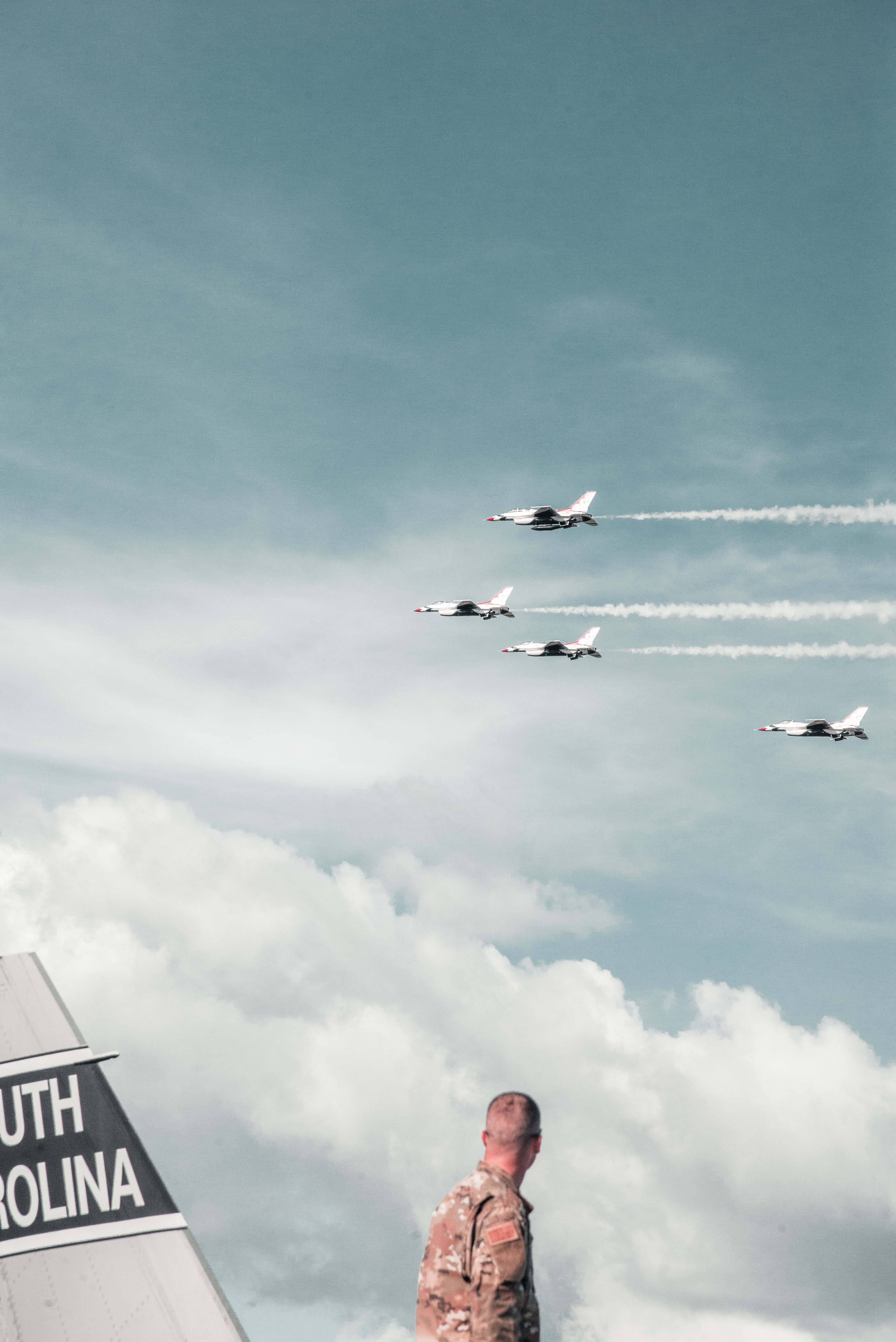 Pictured - A soldier looking over at four fighting jets flying | Source: Pexels 