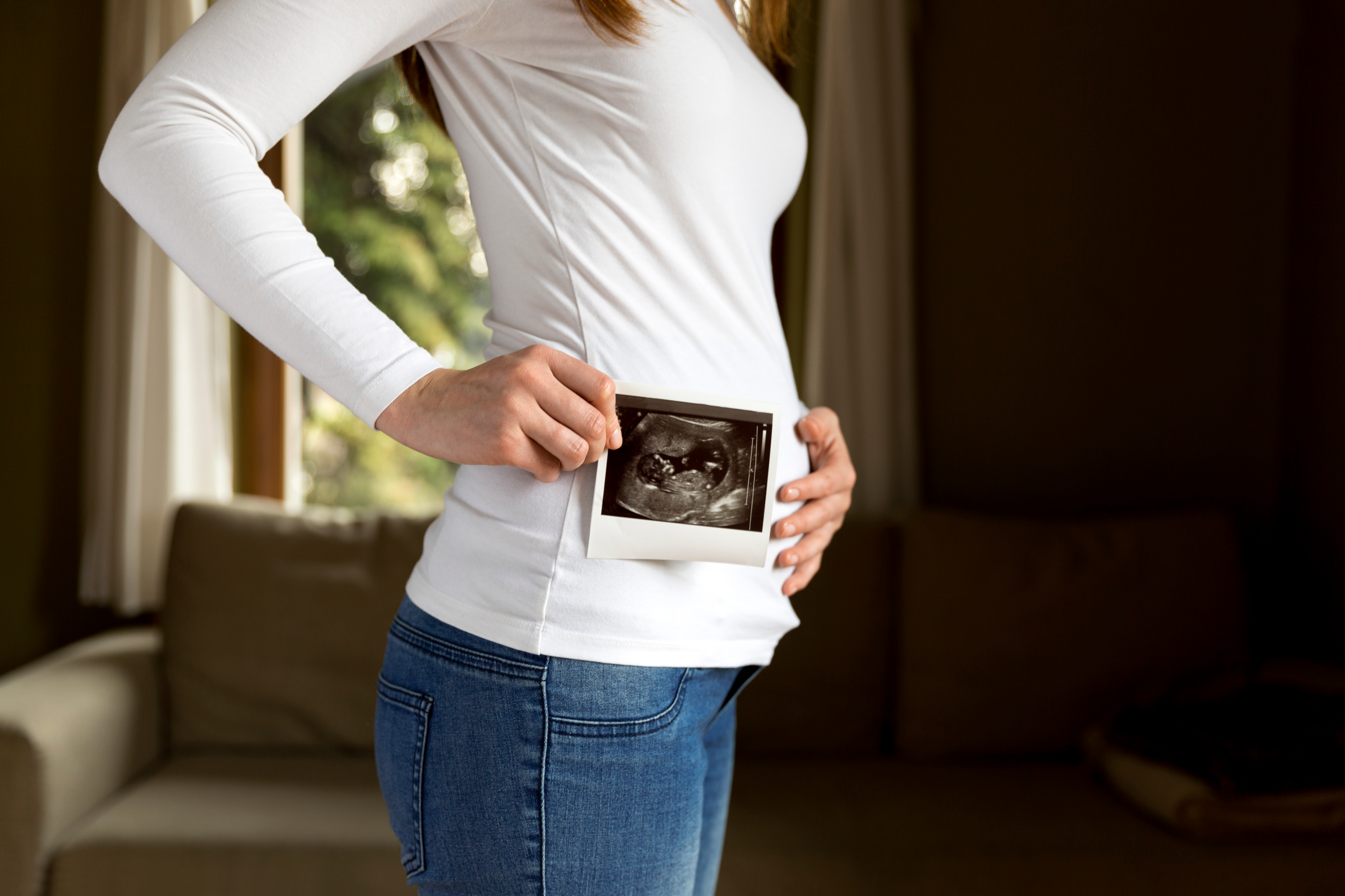 A woman holding an ultrasound scan | Source: Shutterstock