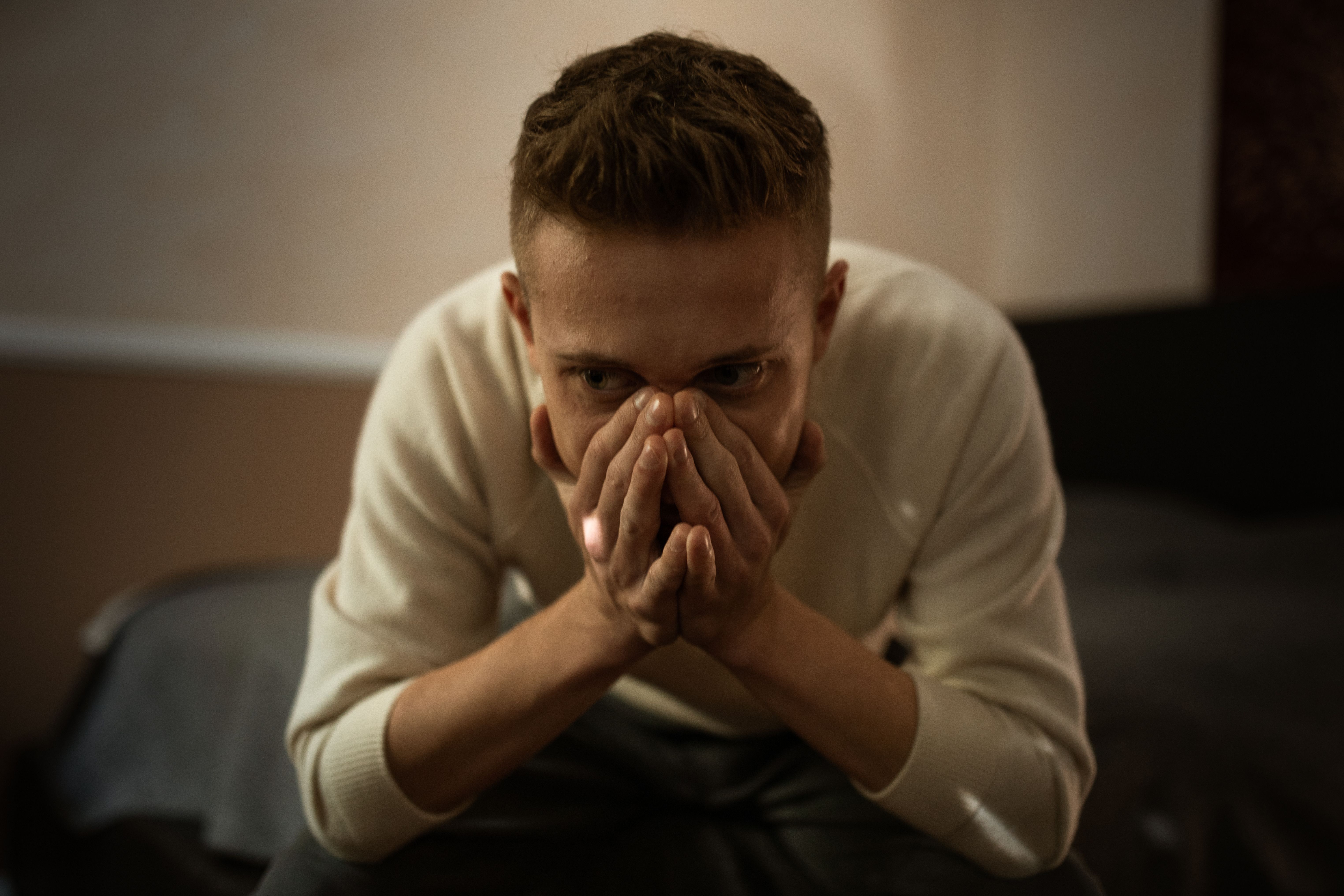 A man leaning and covering his mouth to suppress his emotions | Source: Pexels