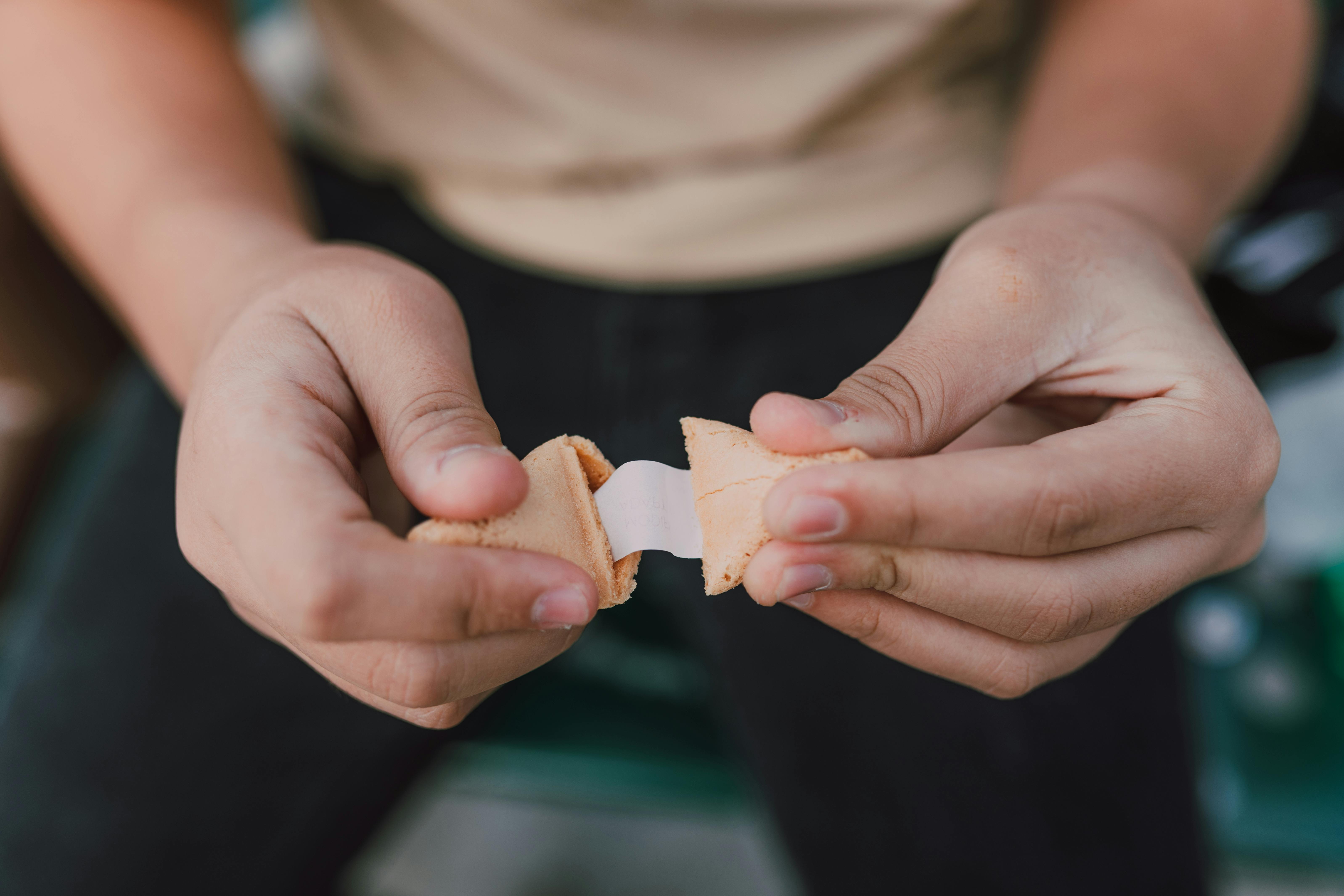 Opening a fortune cookie | Source: Pexels