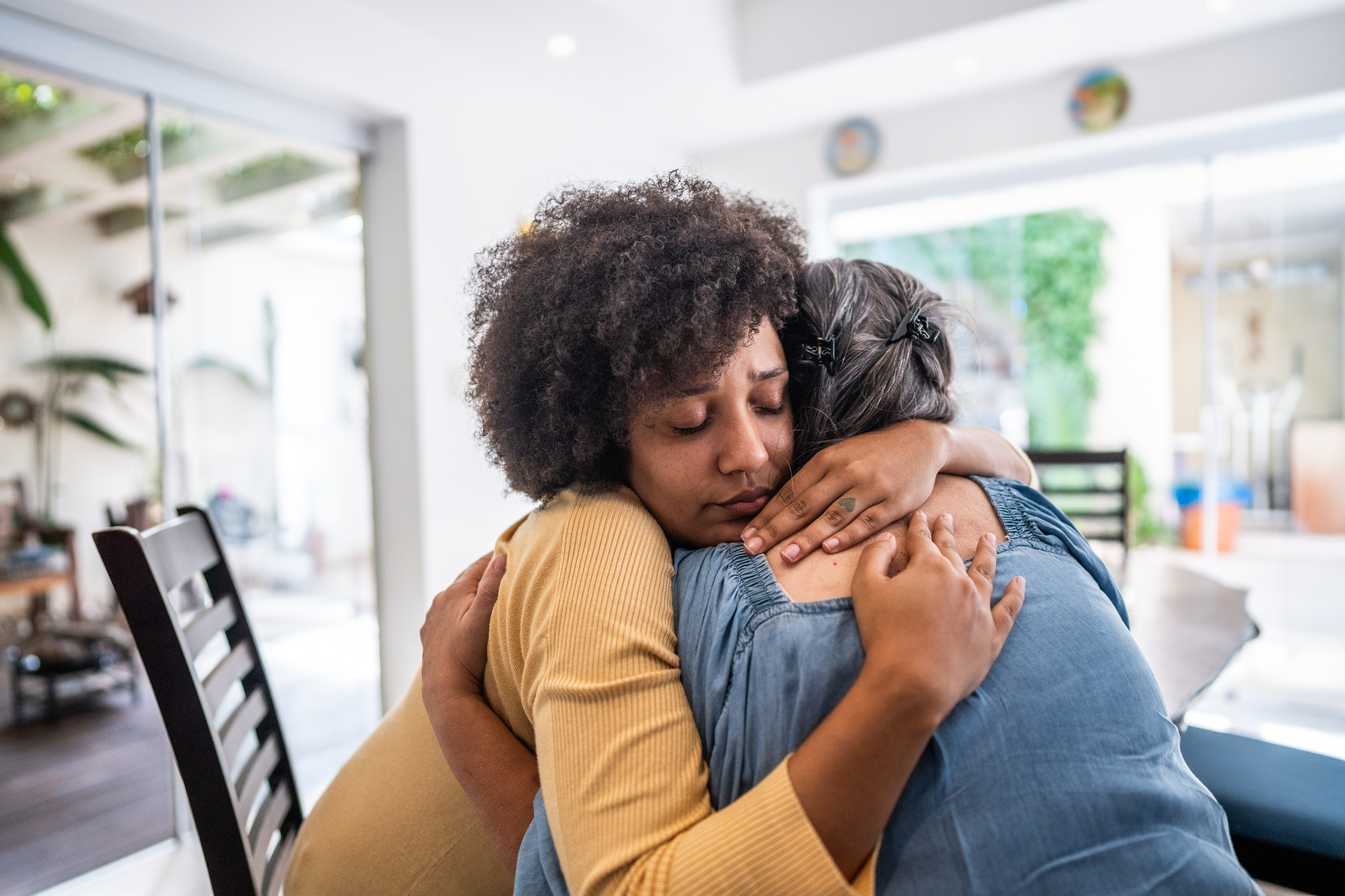 Sad young woman embracing her mother at home | Source: Getty Images