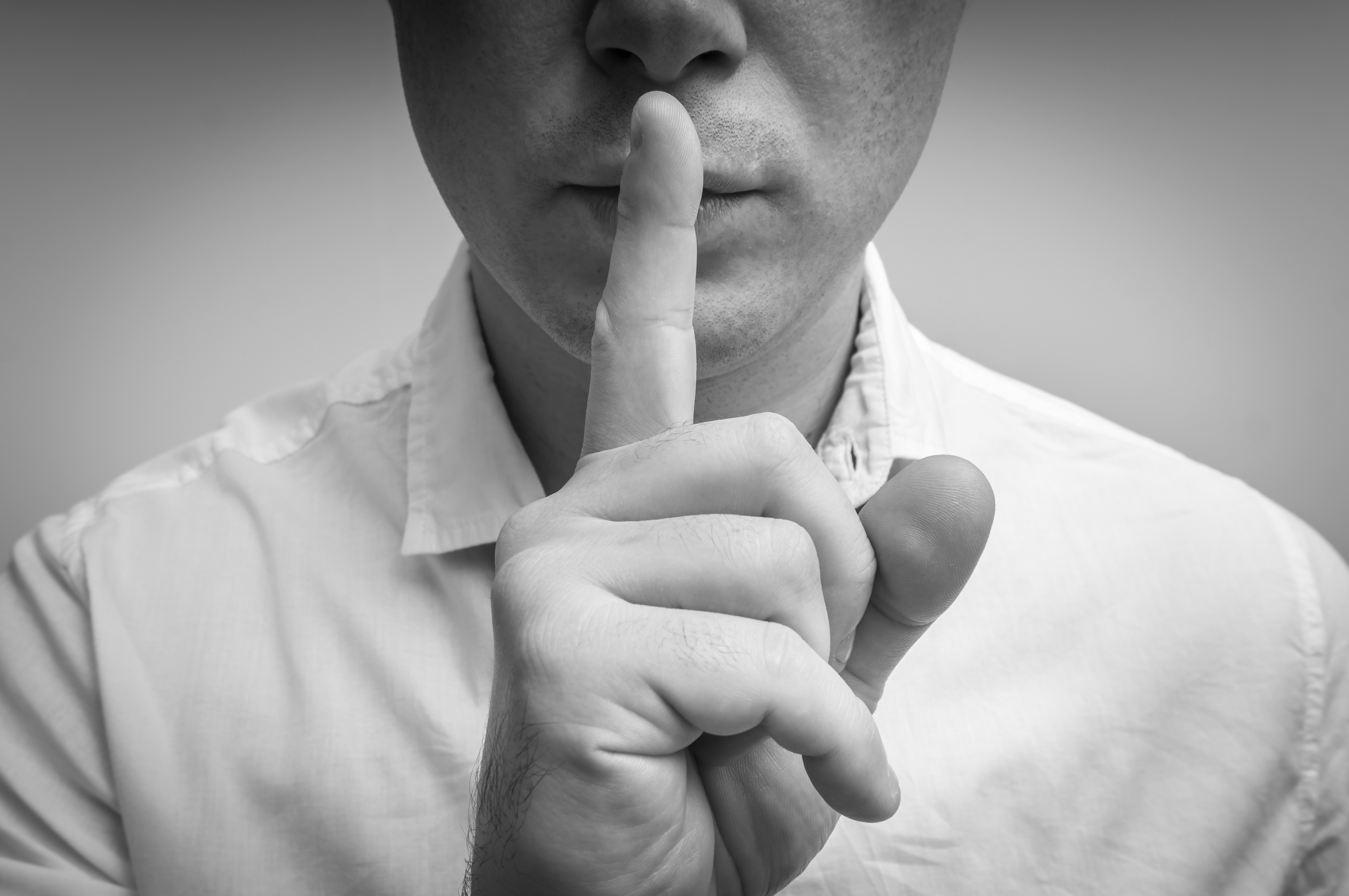 A man with a finger on his lips | Source: Shutterstock