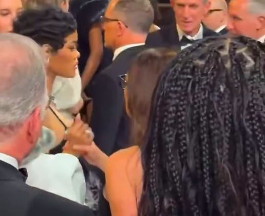 A woman seemingly attempts to calm Teyana Taylor down by holding her hand. | Source: Instagram/popbase