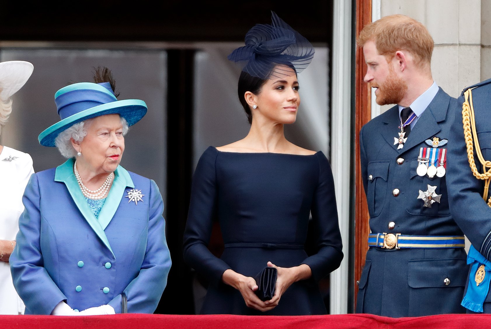 Queen Elizabeth II, Meghan Markle and Prince Harry watching a flypast to mark the centenary of the Royal Air Force from the balcony of Buckingham Palace on July 10, 2018 in London, England. / Source: Getty Images