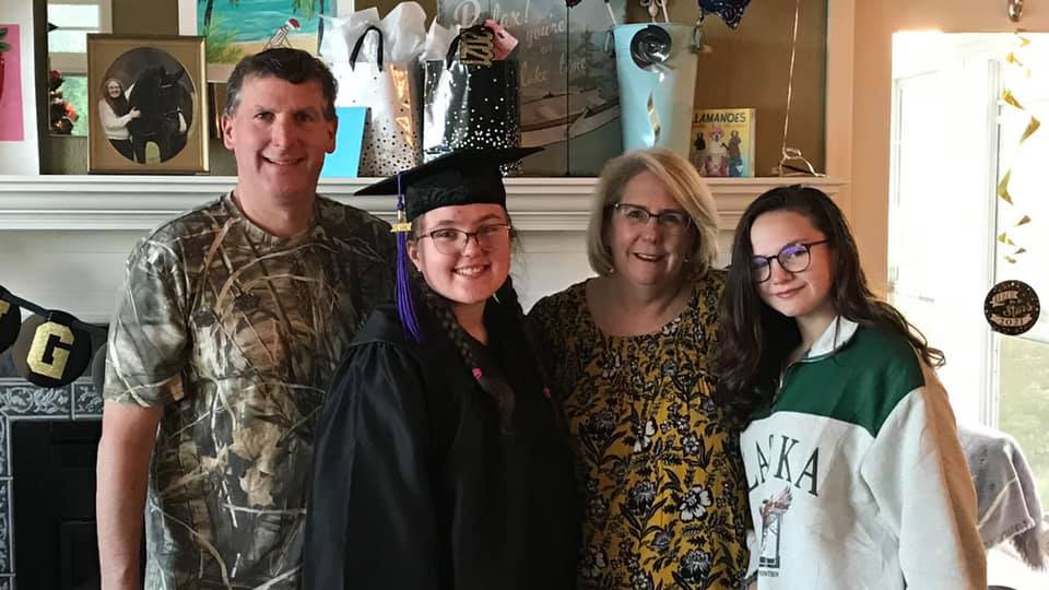 Hallie Marie Tobler poses with her parents, Jeff and Julie Johnson, and her sister Elizabeth | Source: Facebook/julie.johnson.148571