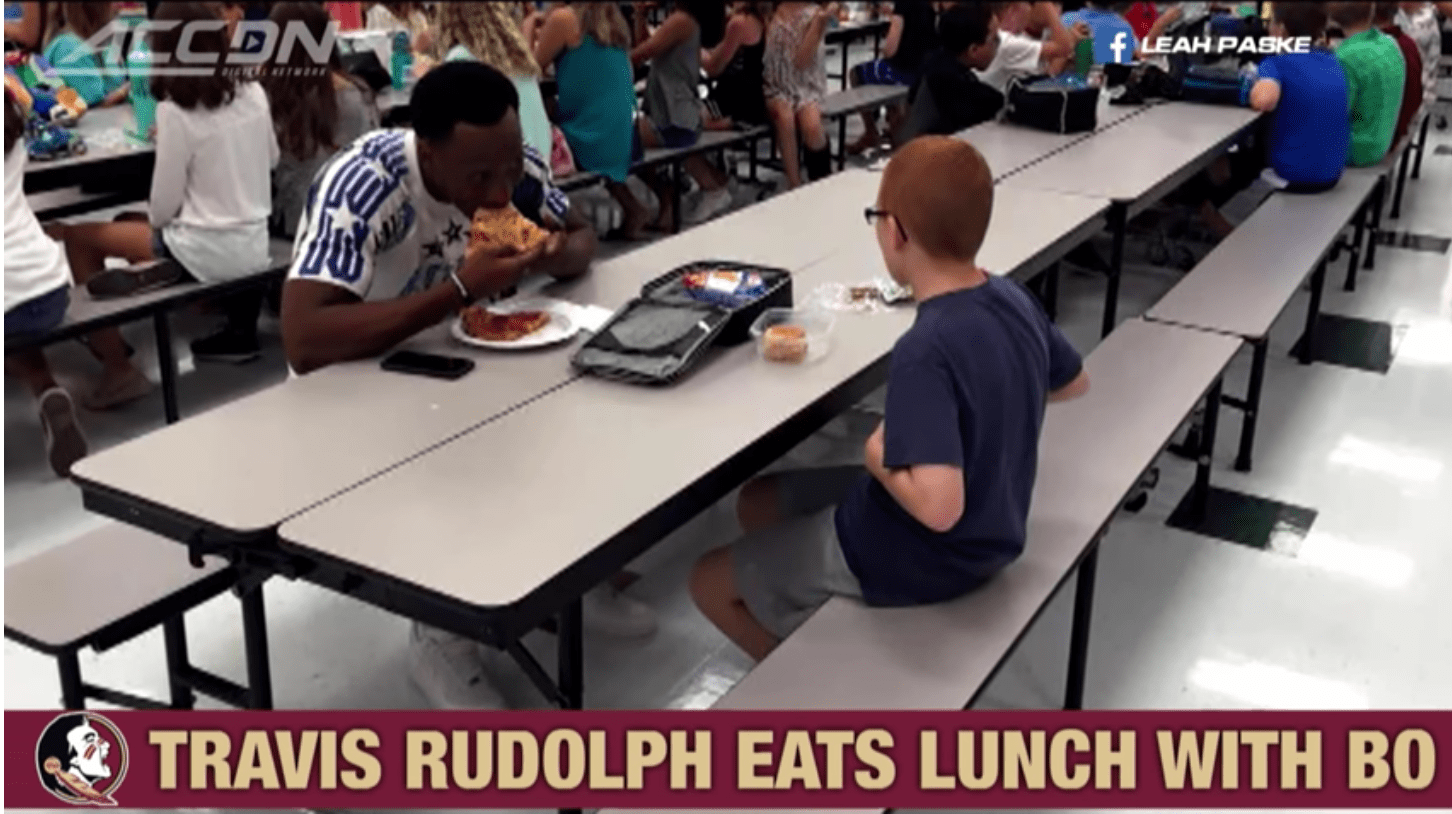 Screenshot of photo of Travis Rudolph sitting with Bo Paske at Montford Middle School in Tallahassee, Florida, 2016. | Source: Youtube/ACC Digital Network