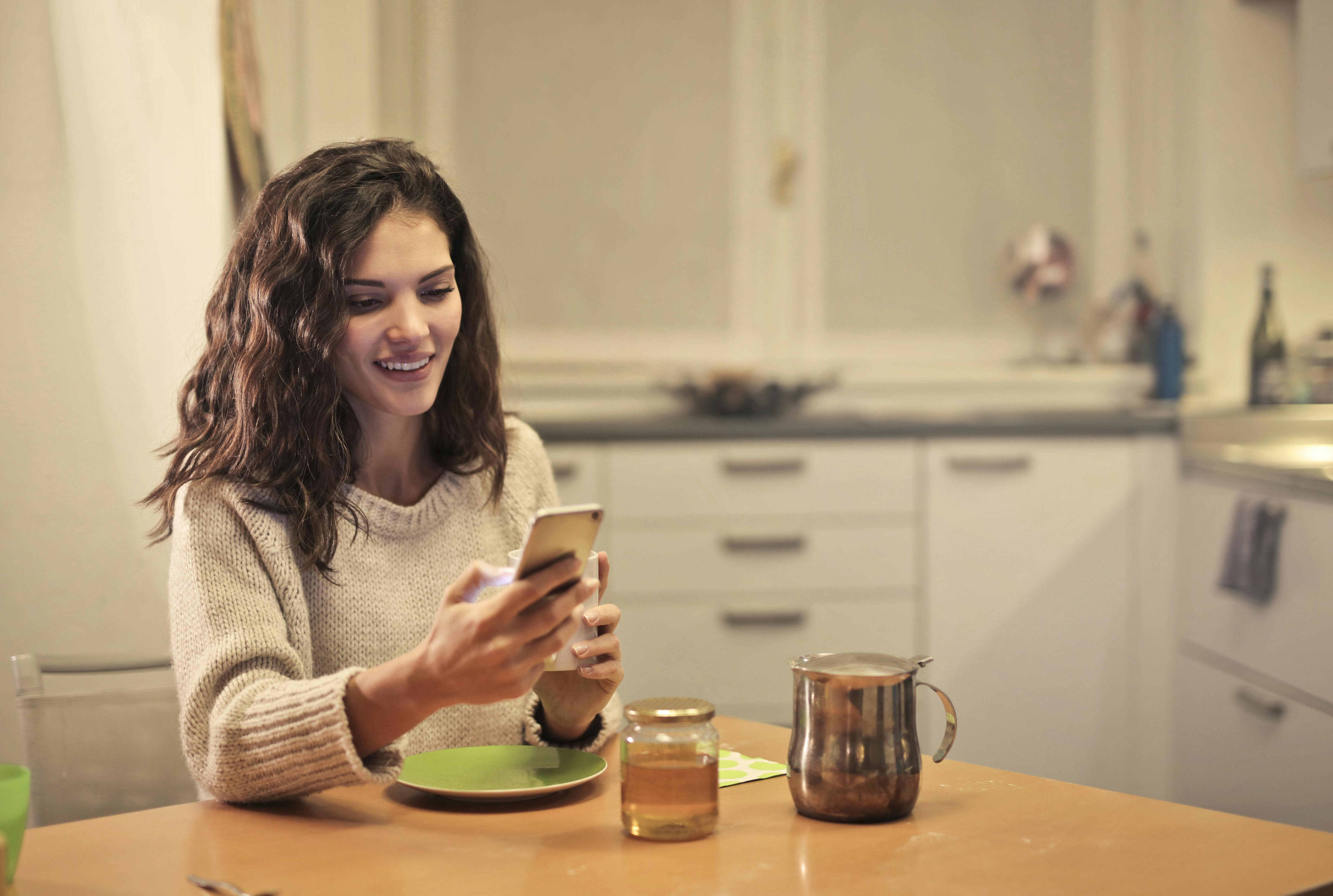 A happy woman looking at her phone | Source: Pexels