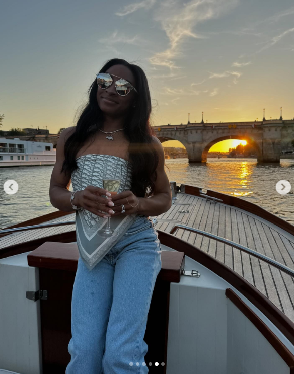 Simone Biles smiles as she enjoys a drink while cruising the River Seine in Paris, France, in a post from August 2024 | Source: Instagram.com/simonebiles