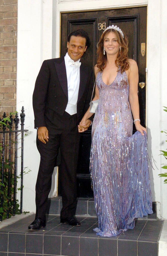 Arun Nayer et Elizabeth Hurley pendant qu’Elizabeth Hurley quitte sa maison pour assister à la cravate blanche et au bal de diadème d'Elton John - 23 juin 2005 à une résidence privée à Londres, en Grande-Bretagne. | Photo : Getty Images Arun Nayer et Elizabeth Hurley pendant qu’Elizabeth Hurley quitte sa maison pour assister à la cravate blanche et au bal de diadème d'Elton John - 23 juin 2005 à une résidence privée à Londres, en Grande-Bretagne. | Photo : Getty Images