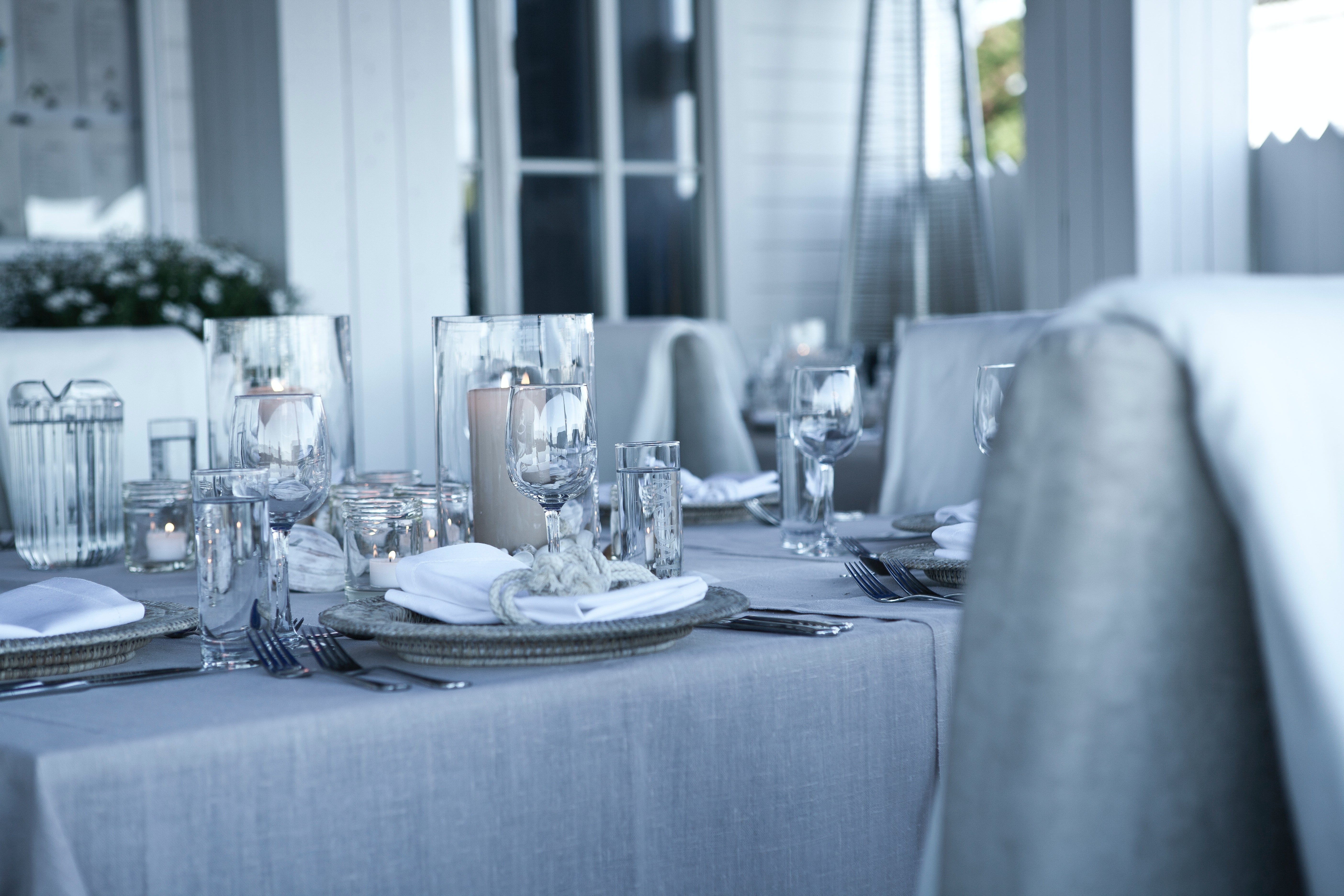 An image of clear glass dinnerware on top of a table which is covered by a gray table cloth | Source: Pexels 