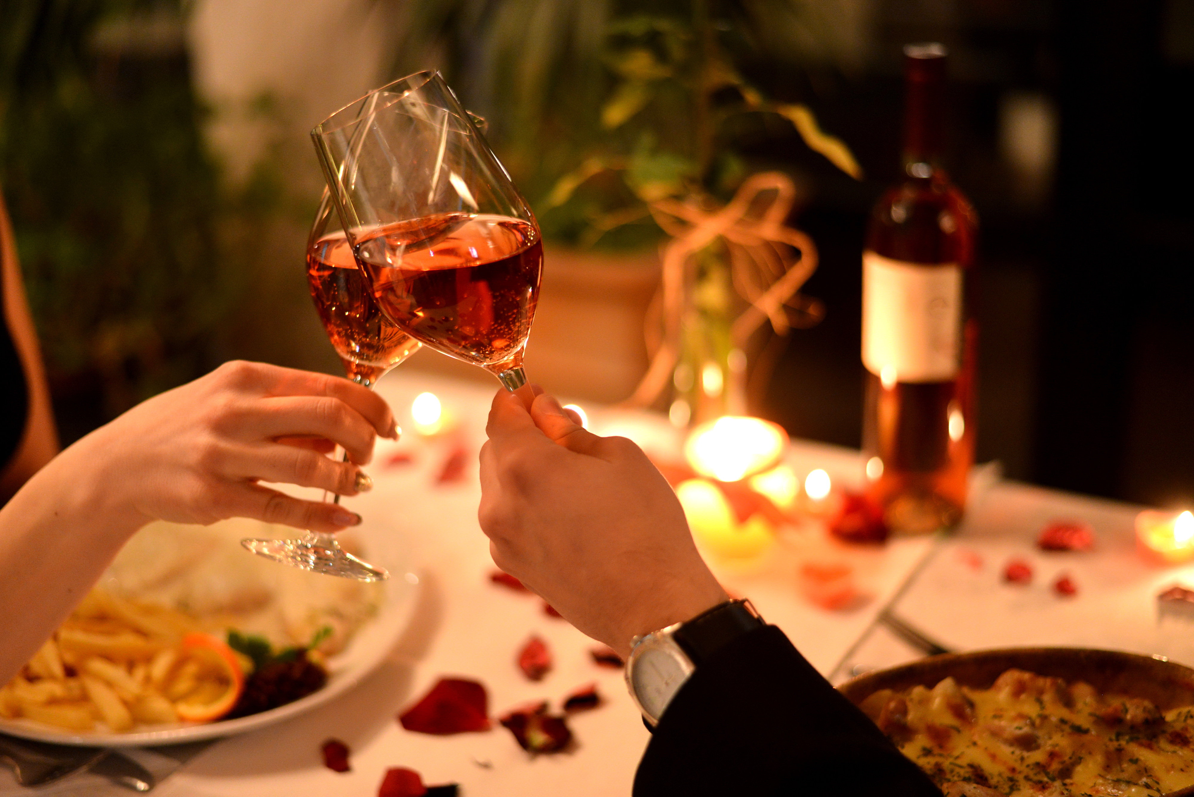 A couple clinking wine glasses during a romantic dinner | Source: Shutterstock