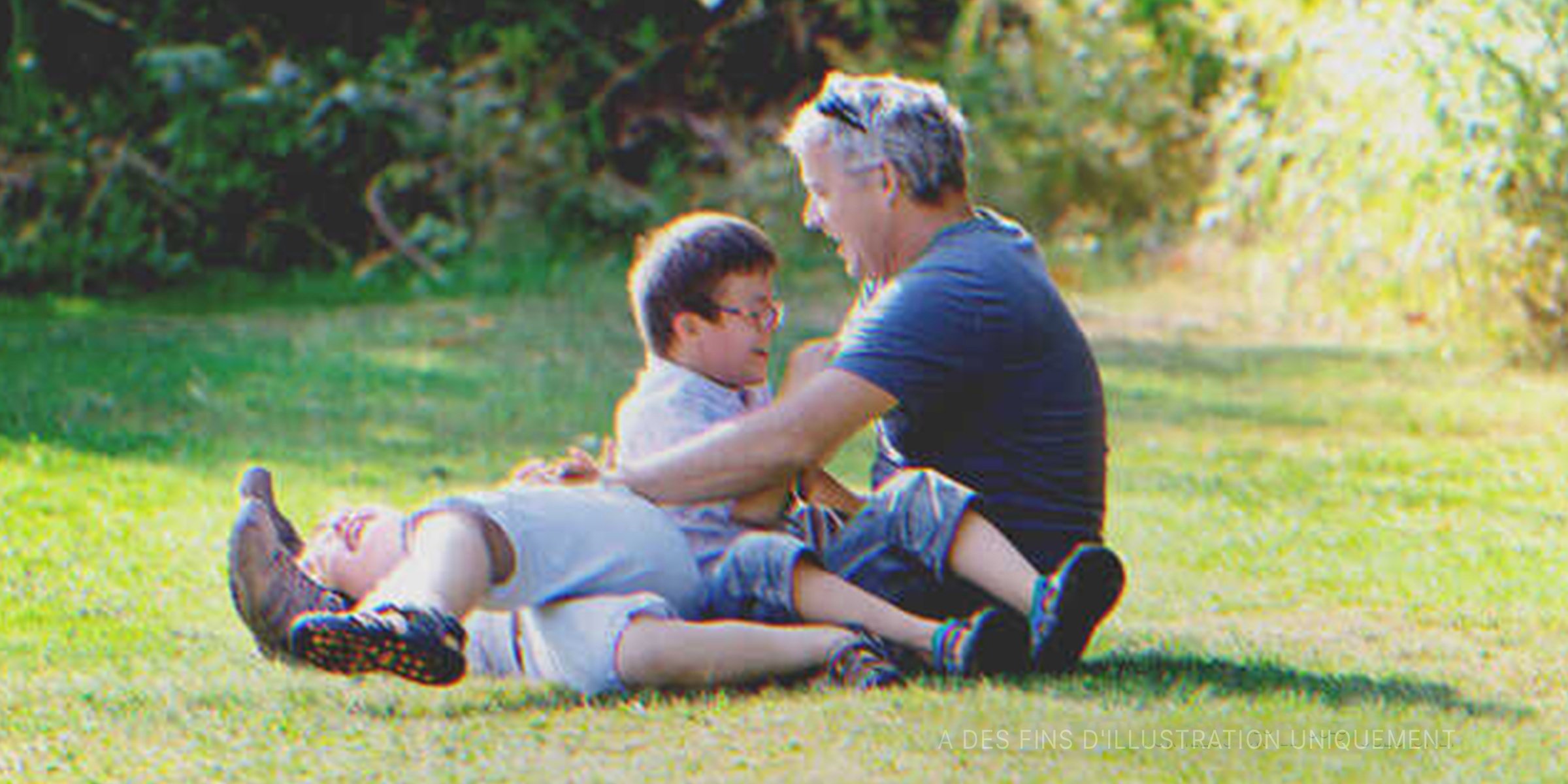 Deux petits garçons jouant avec un homme | Source : Getty Images