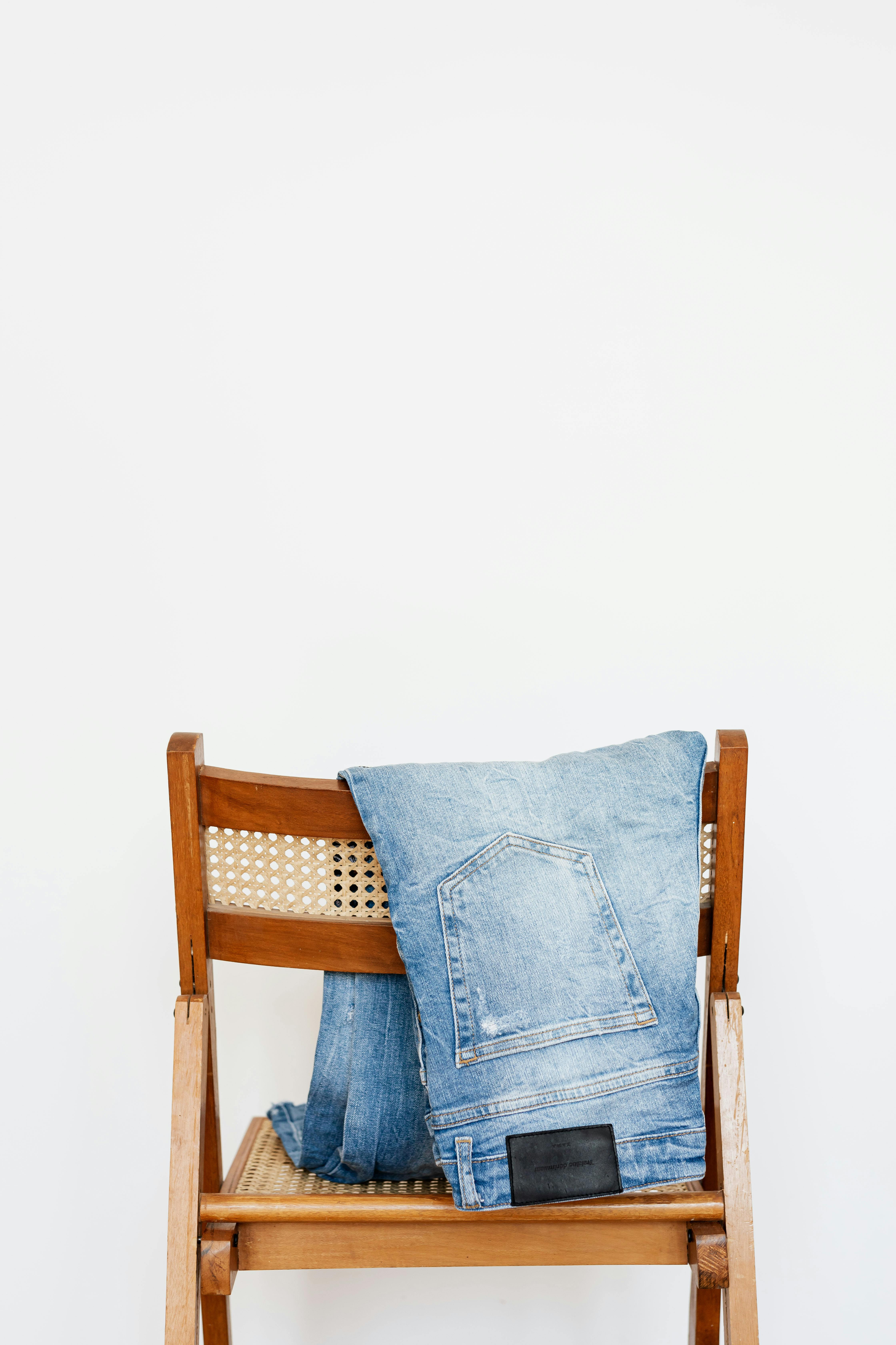 A pair of jeans hanging on a chair | Source: Pexels