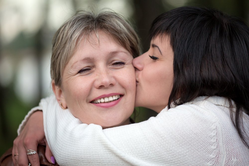 La mujer abraza y besa a su madre. Fuente: Shutterstock