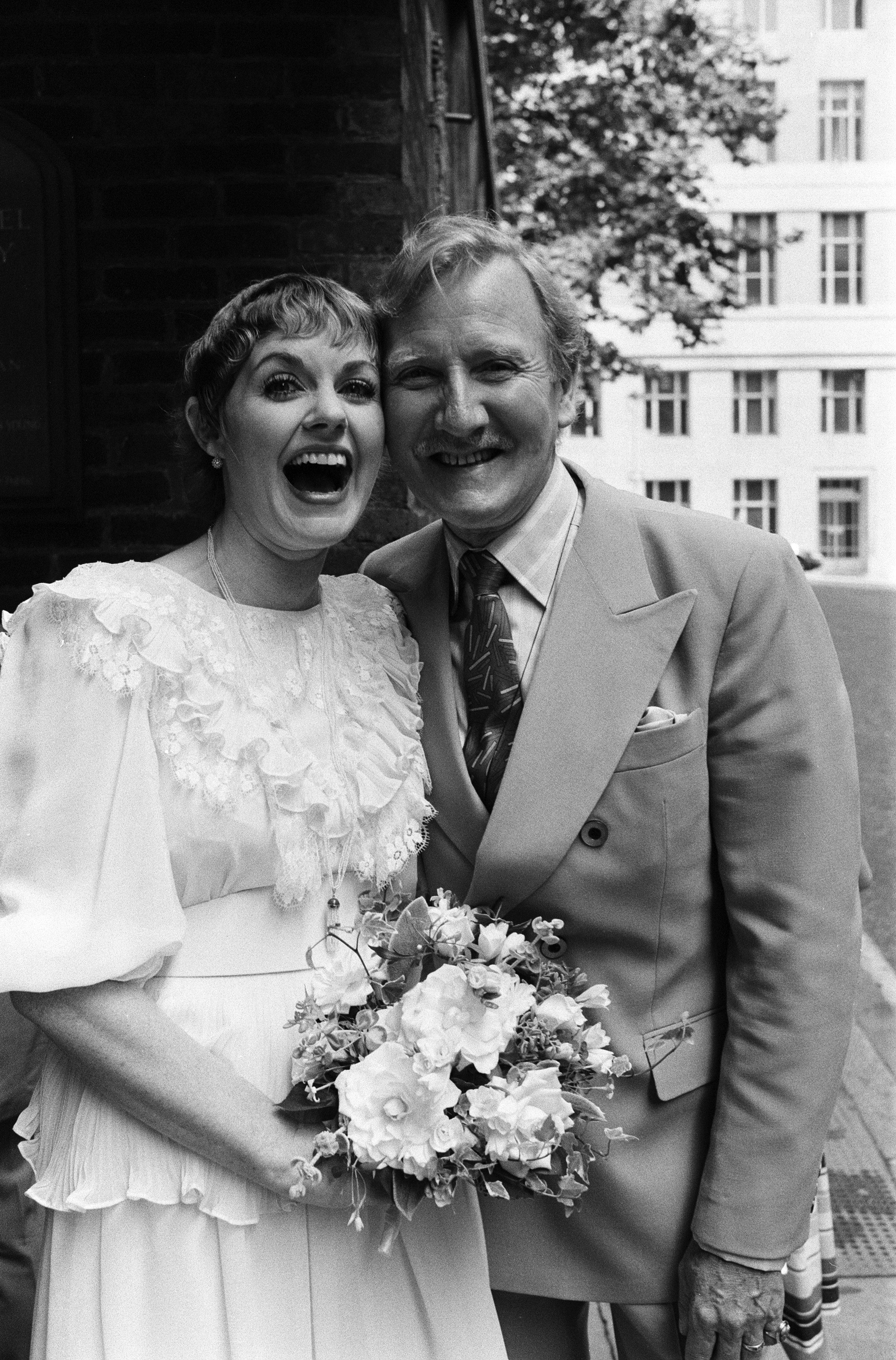 Angela Scoular and Leslie Phillips marry at the Queen's Chapel of the Savoy, on July 31, 1982 | Source: Getty Images