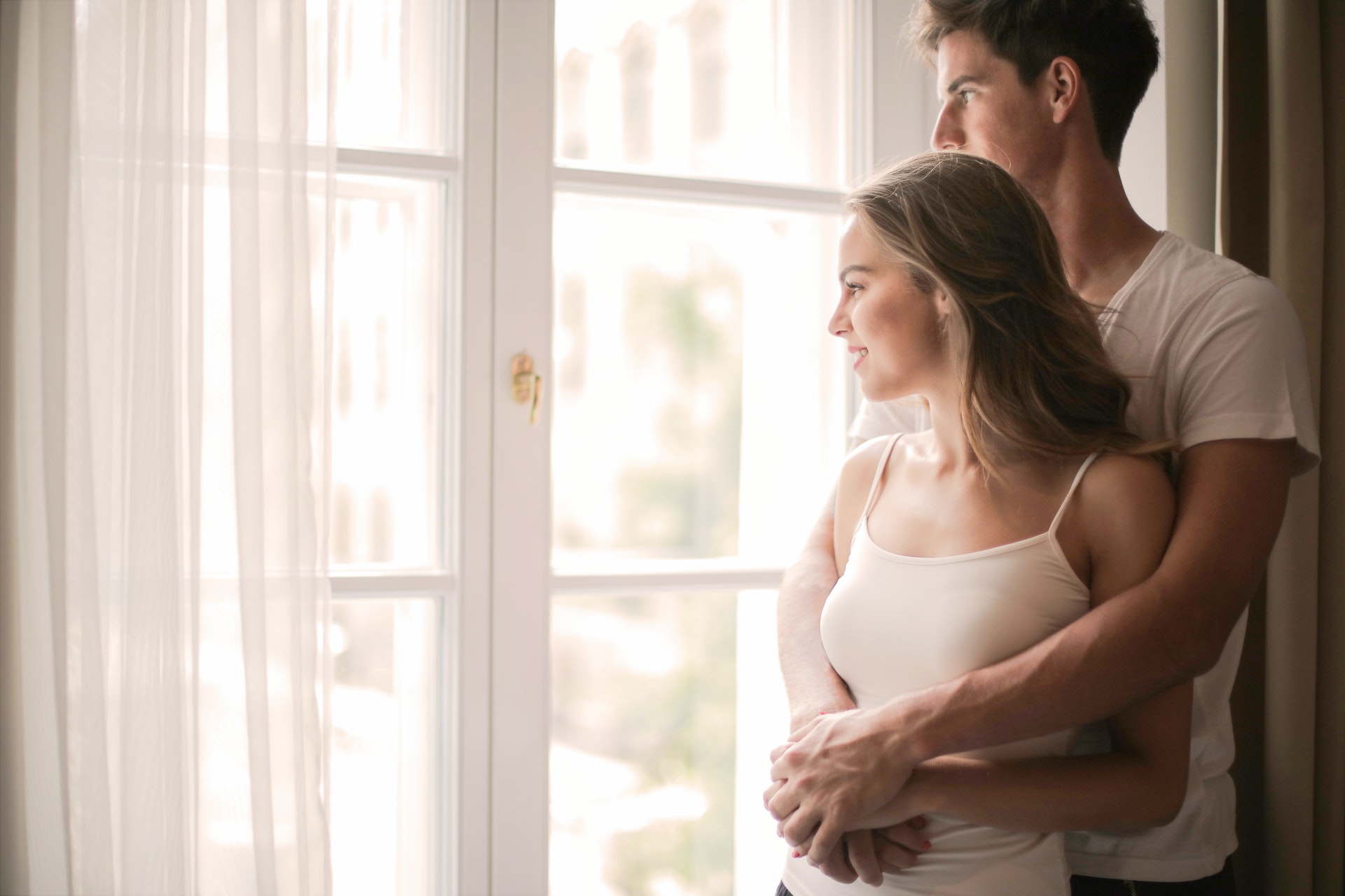 A man and woman standing by a window | Source: Pexels