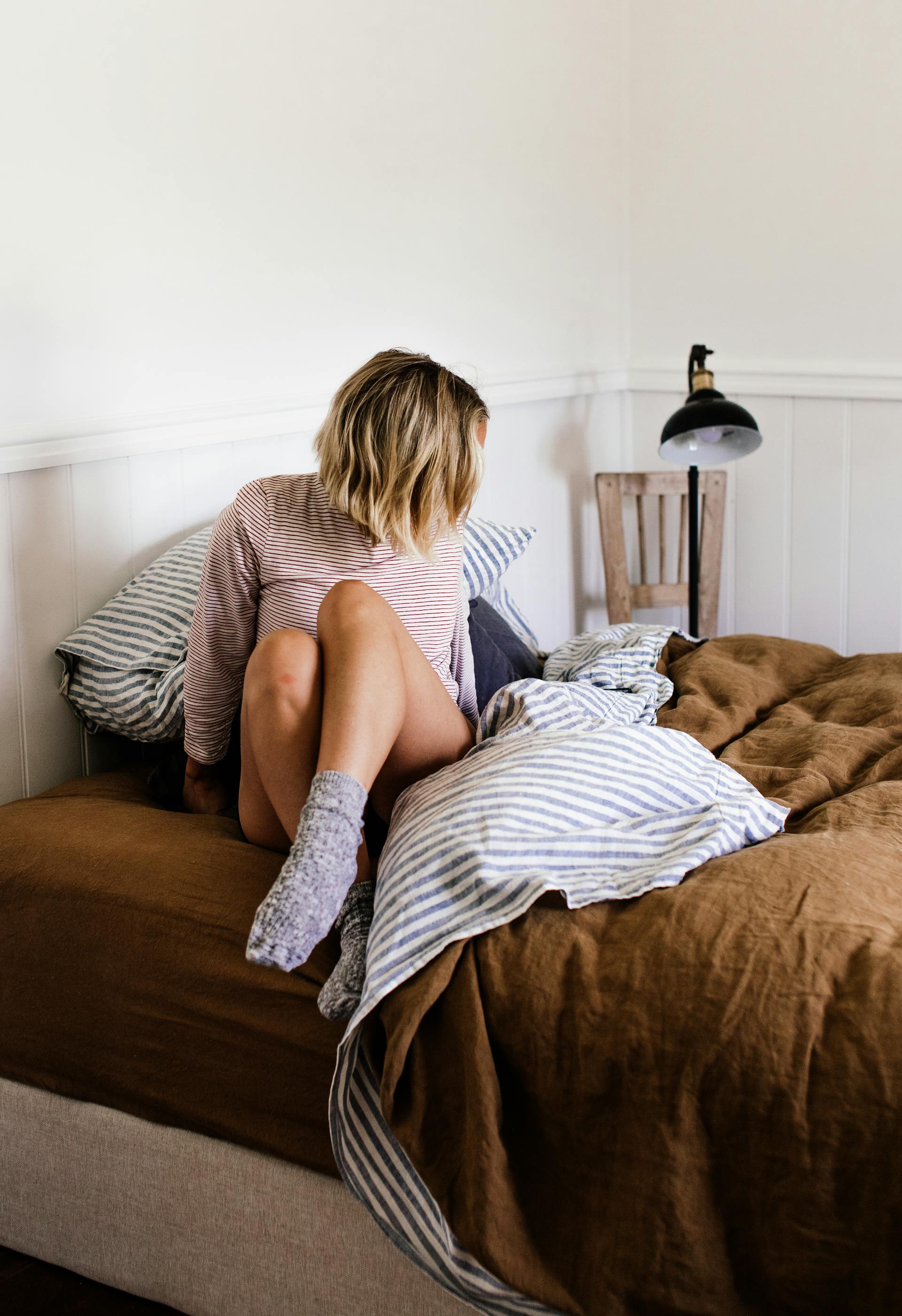 A woman getting into bed | Source: Pexels