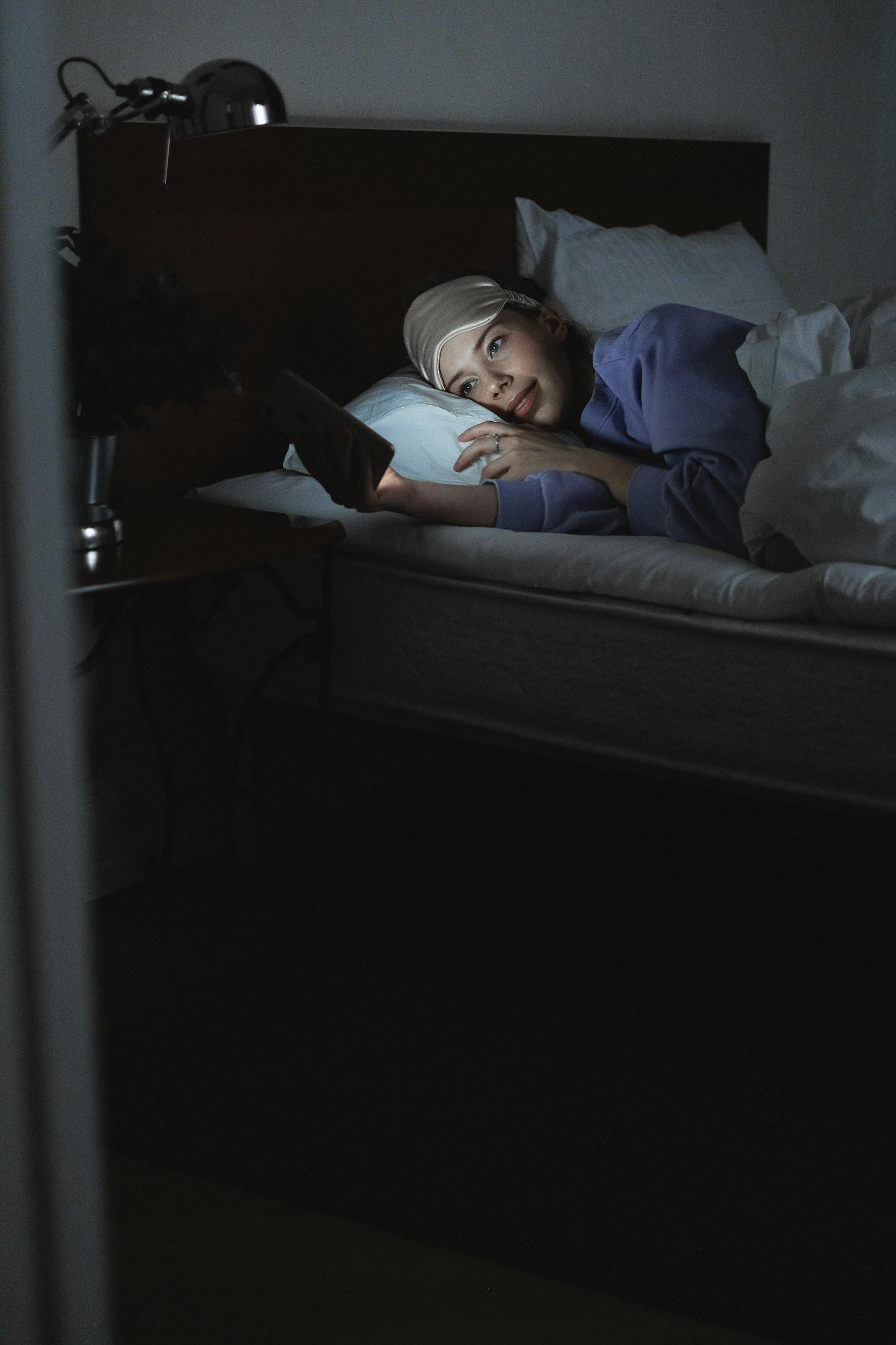 A woman using her phone in bed | Source: Pexels