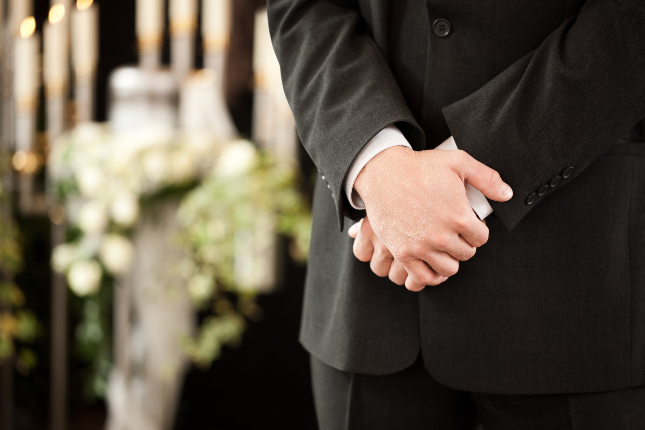 Ein Mann in einem schwarzen Anzug während einer Beerdigung. I Quelle: Getty Images