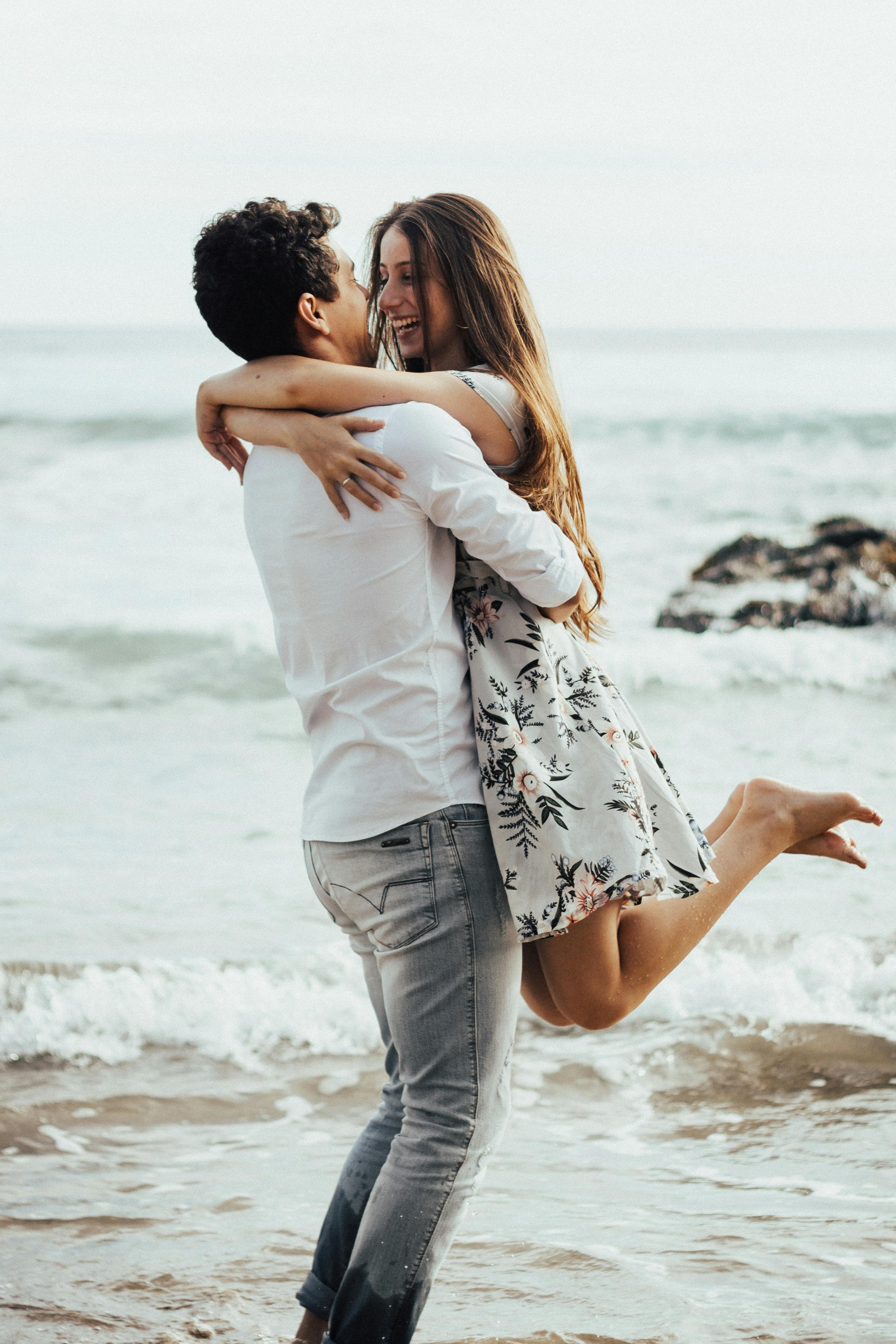 A happy couple embracing at the beach | Source: Pexels