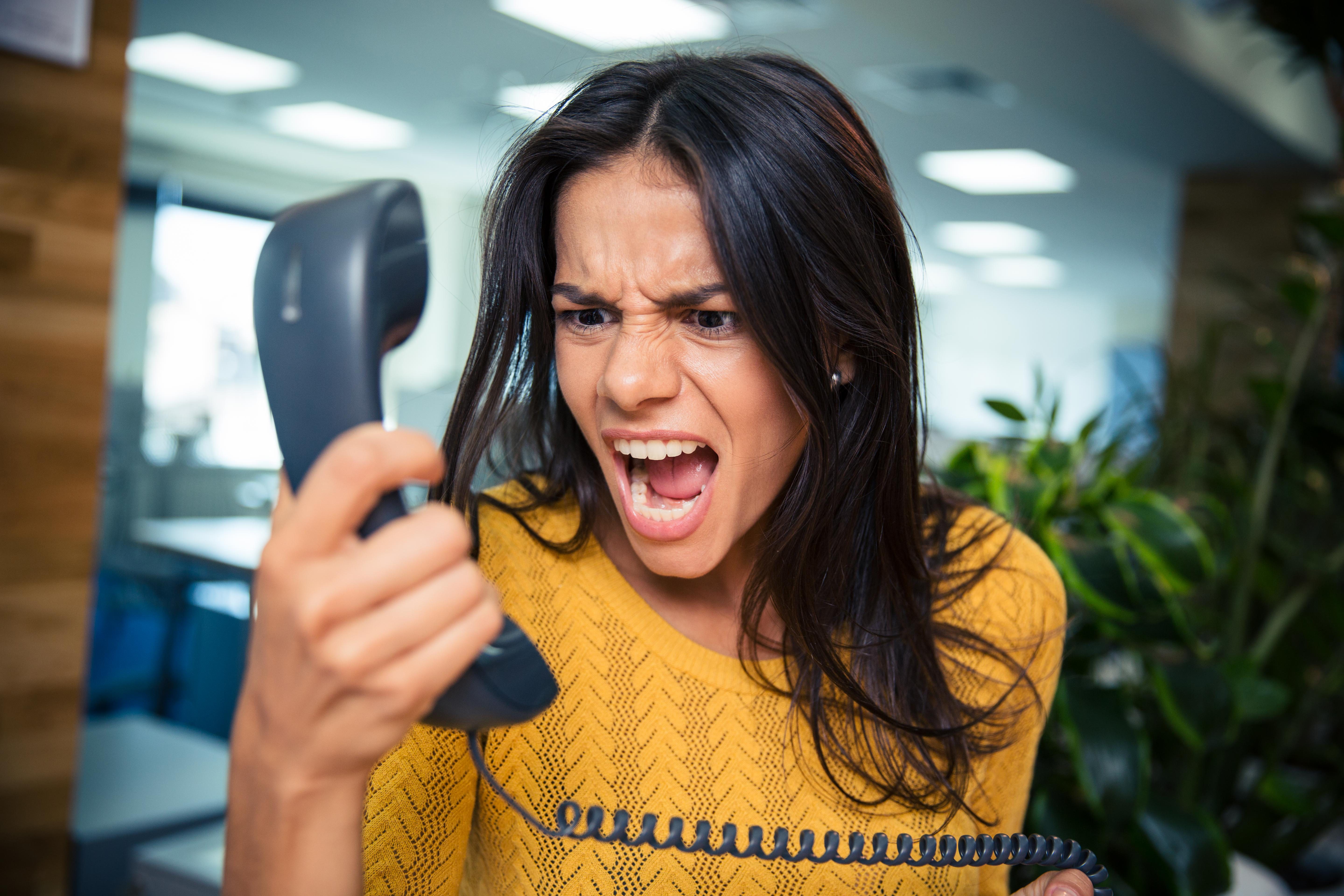 A woman yelling into the phone | Source: Shutterstock