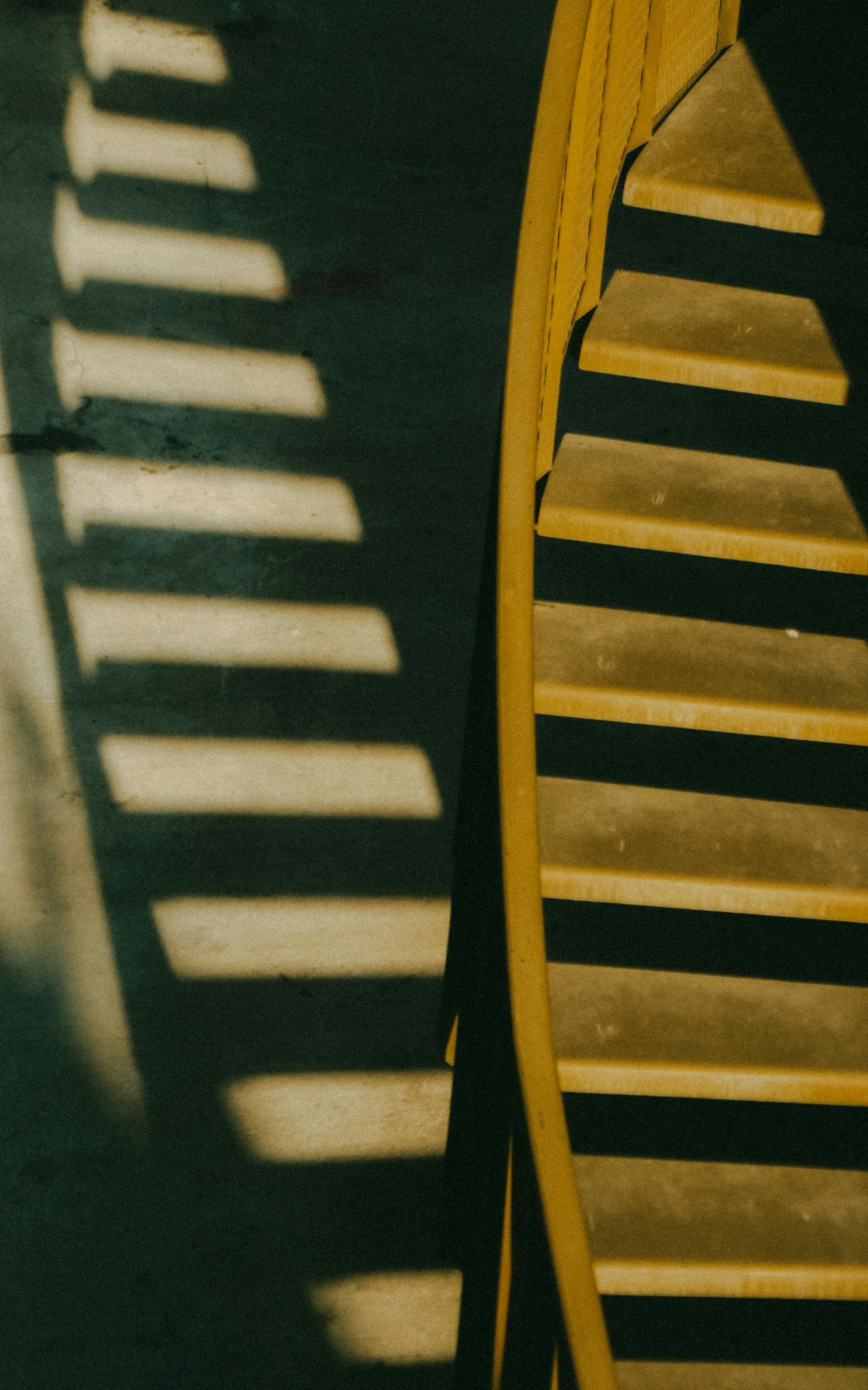 A photo showing shadows being cast on the wall by a curved staircase | Source: Pexels