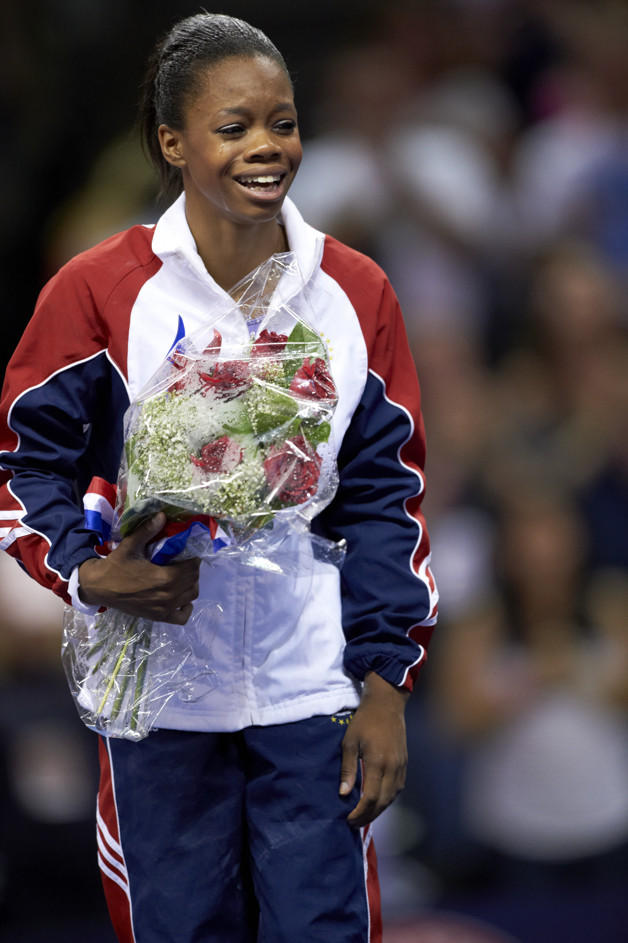 Gabrielle Douglas victorious with floral bouquet after Women's competition at HP Pavilion on July 1, 2012. | Source: Getty Images