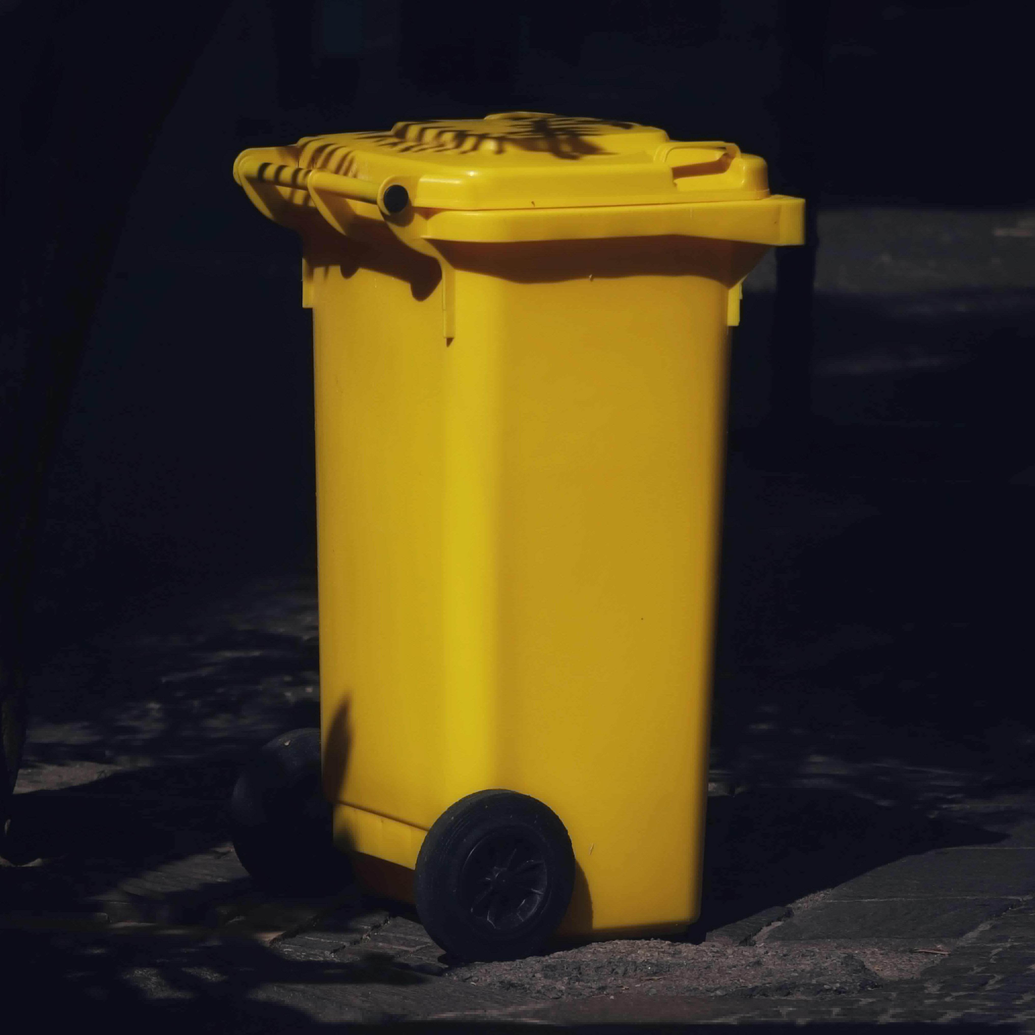 A brightly-colored trash can in a backyard | Source: Pexels