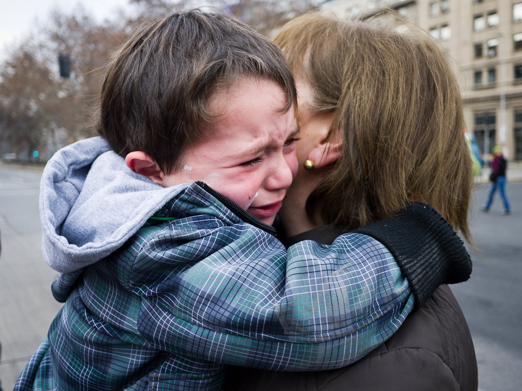 Mujer sosteniendo en brazos a un niño llorando. | Imagen: Flickr Mujer sosteniendo en brazos a un niño llorando. | Imagen: Flickr