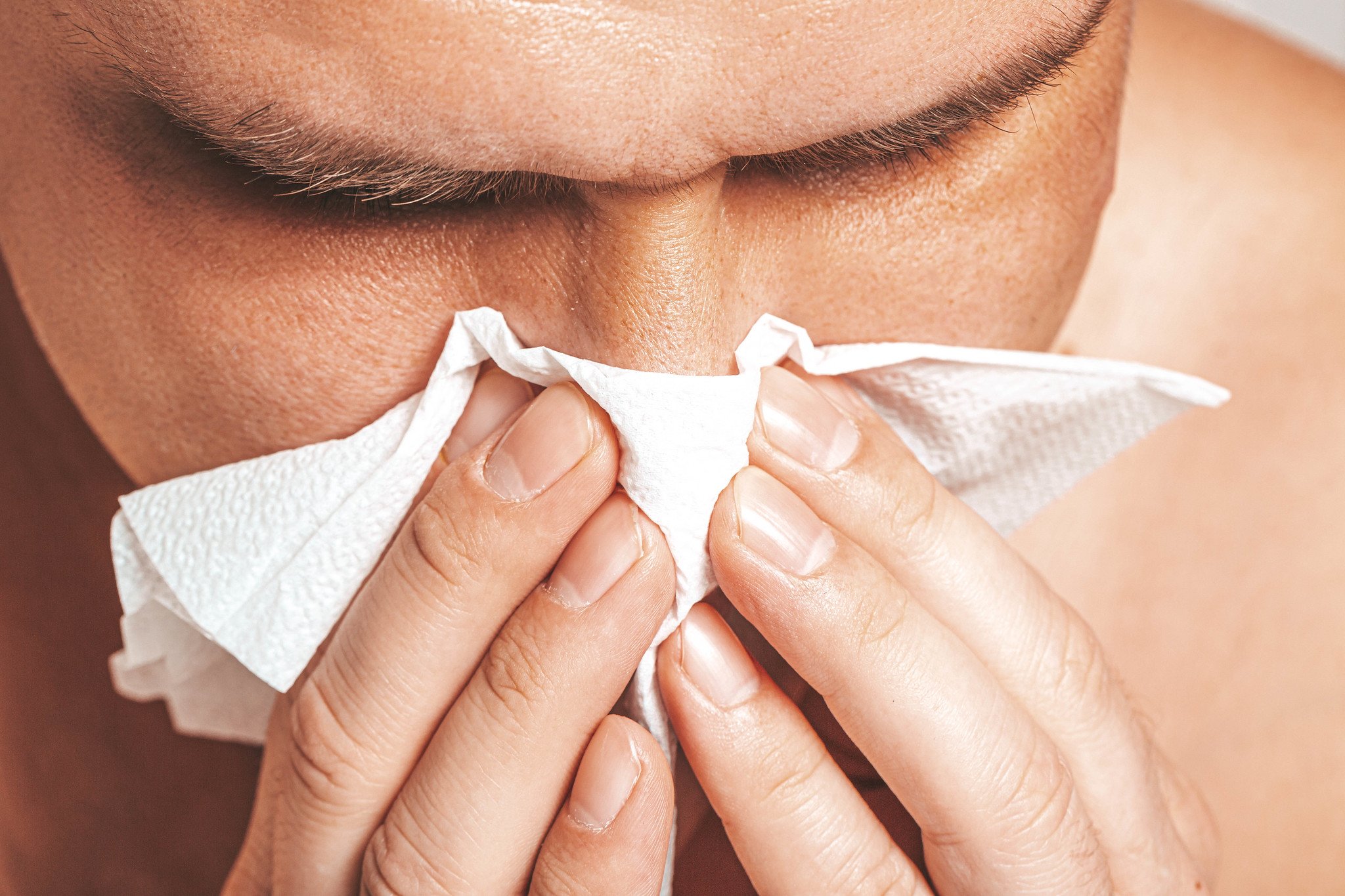 Hombre soplándose la nariz con una servilleta. | Foto: Flickr