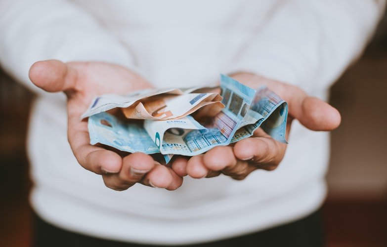 A photo of a man with his hands stretched asking for money. | Photo: Unsplash