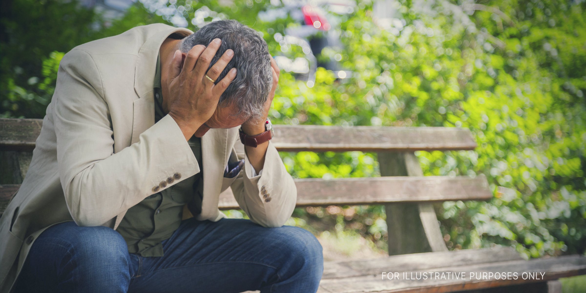 Stressed man sitting on a bench. | Source: Getty Images