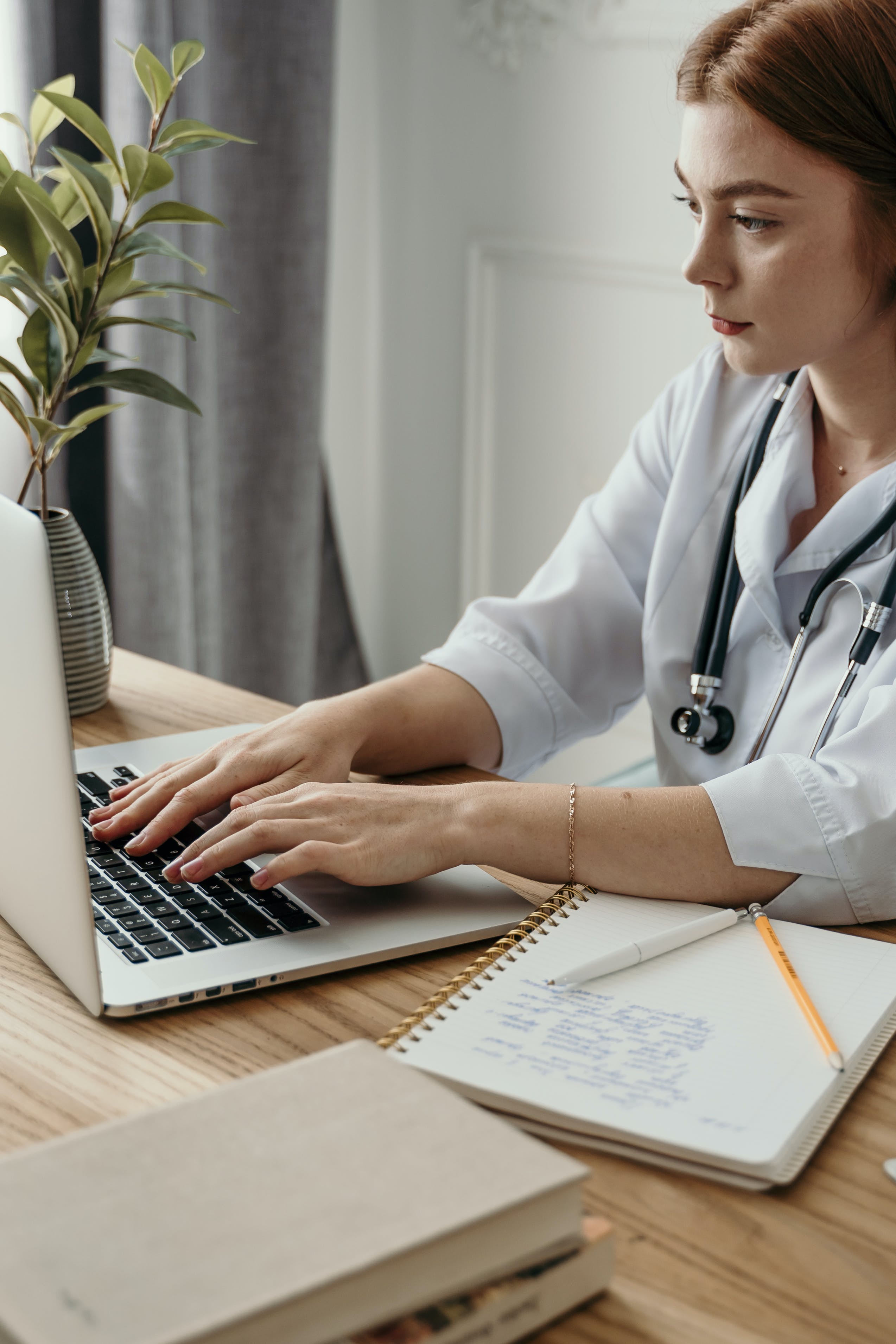 A doctor typing on her laptop. | Source: Pexels