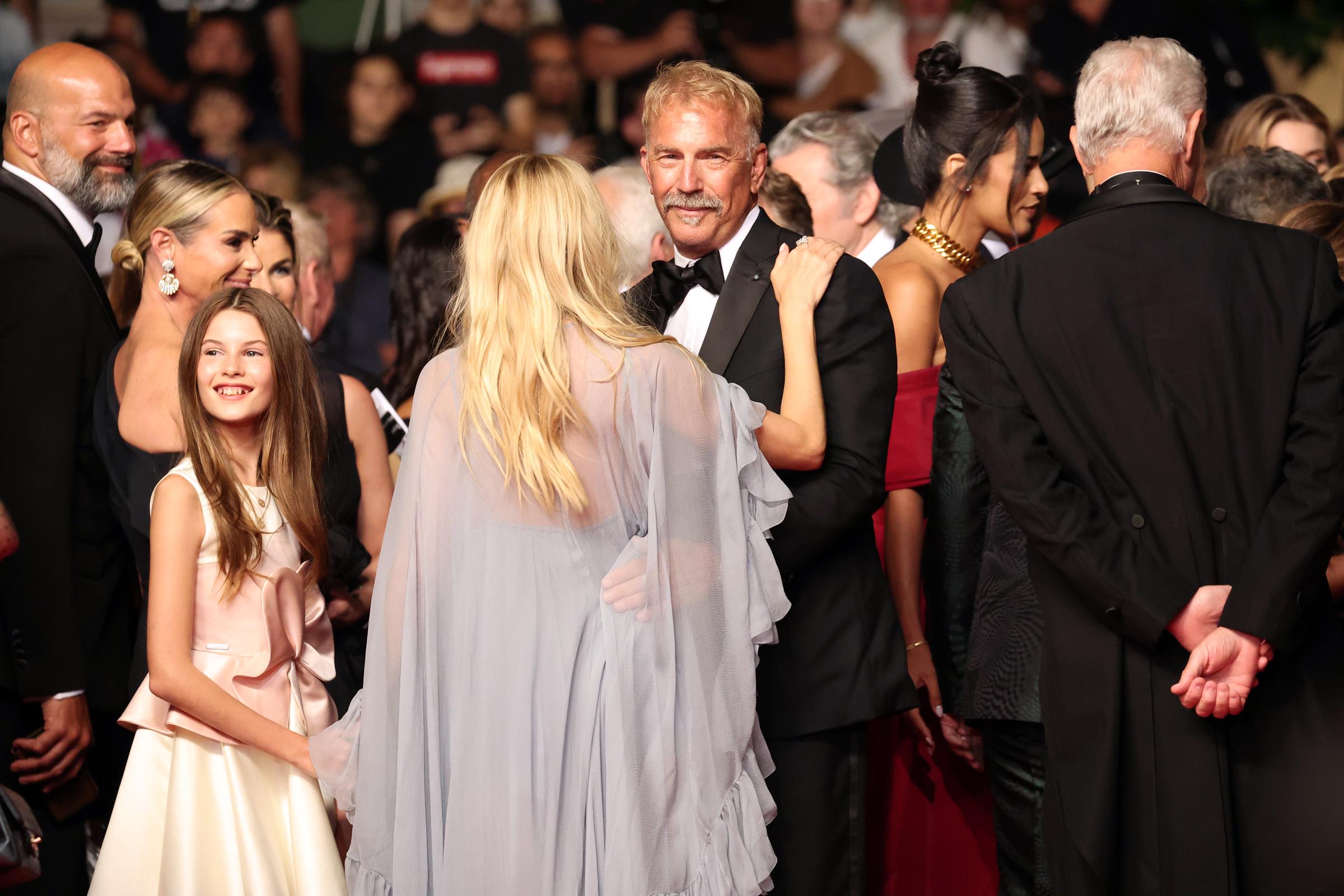 Marlowe Sturridge smiles next to Sienna Miller and Kevin Costner at the 2024 Cannes Film Festival. | Source: Getty Images