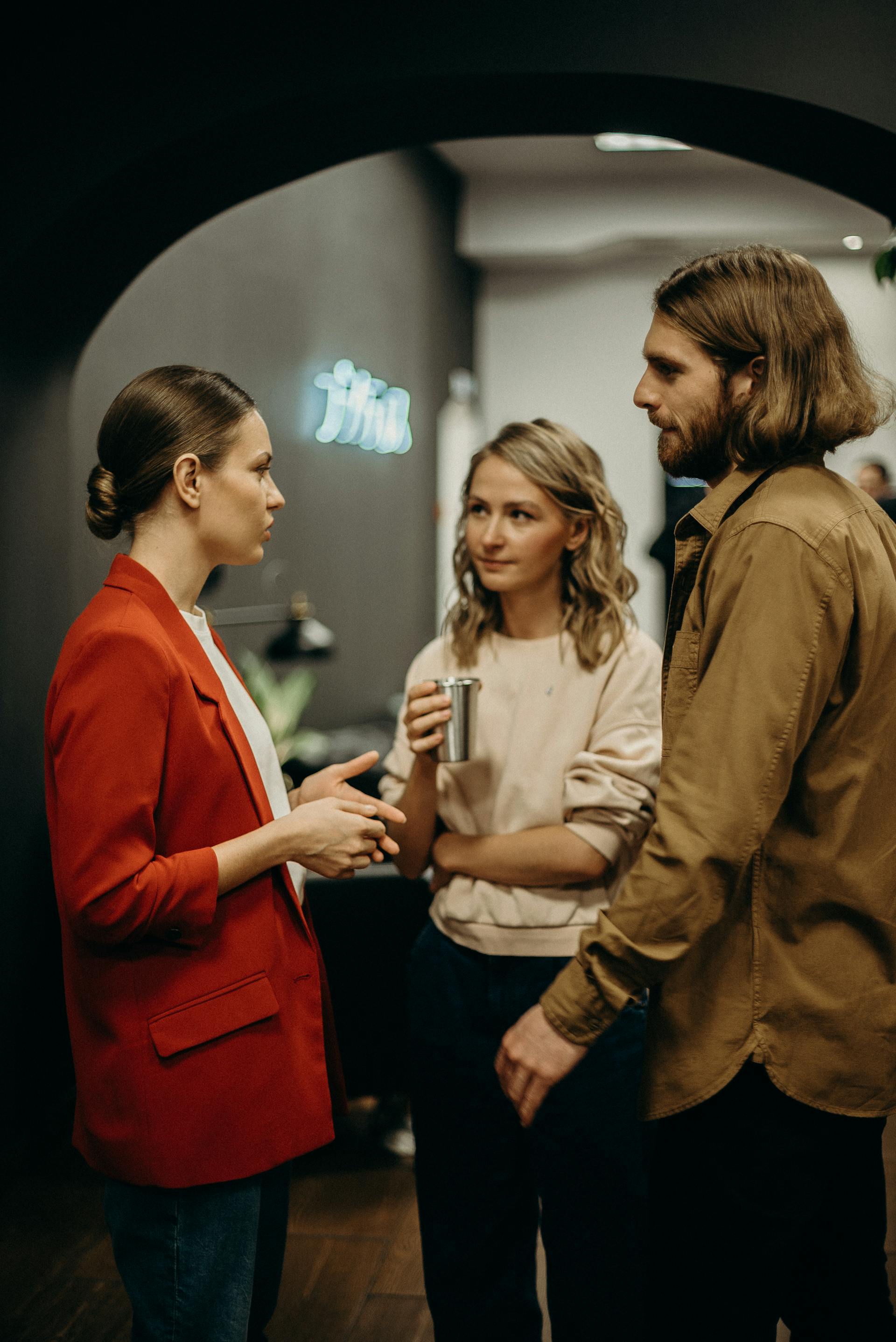 Colleagues talking in an office setting | Source: Pexels