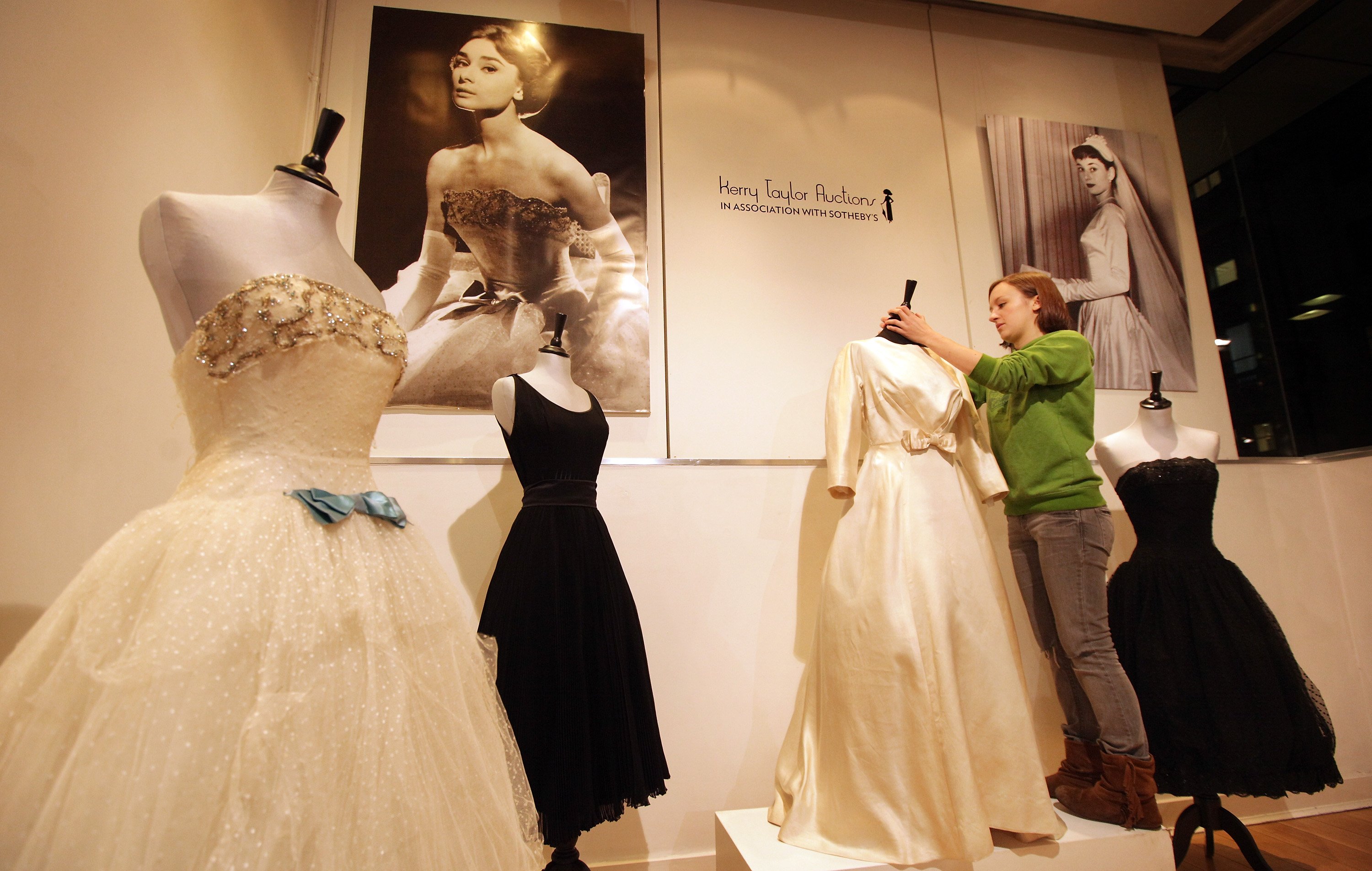 Un miembro del personal de The Kerry Taylor Auctions ajusta el vestido nupcial de Audrey Hepburn el 4 de diciembre de 2009 en Londres. | Foto: Getty Images