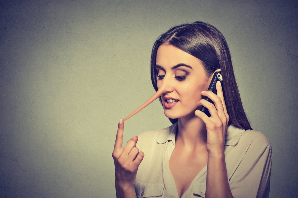 Portrait de jeune femme disant des mensonges sur portable. | Shutterstock