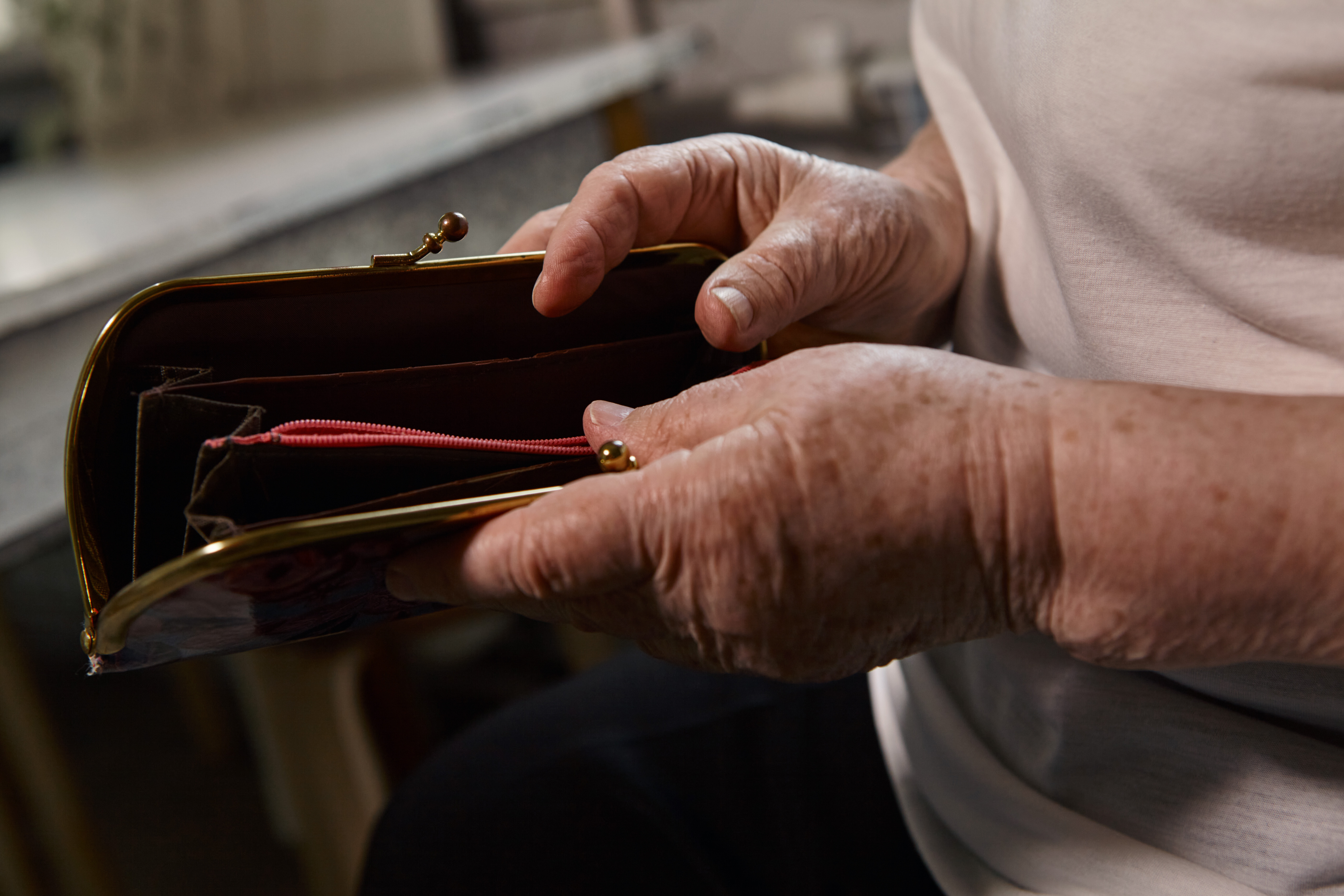 An older woman holding an empty wallet | Source: Shutterstock