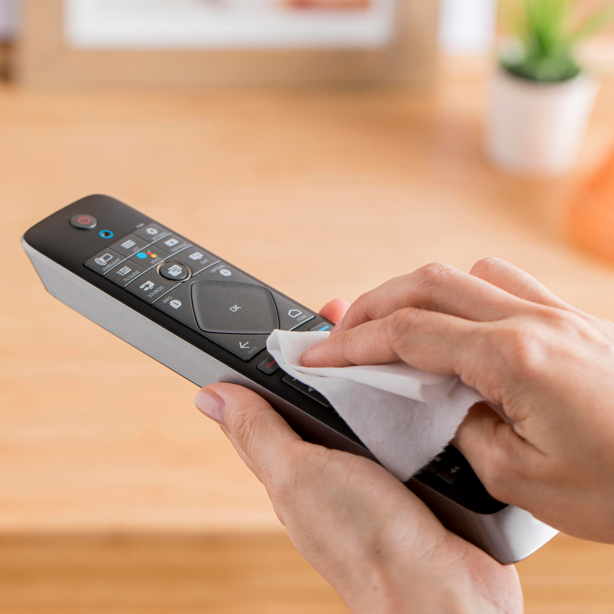 Someone disinfecting a television remote control | Source: Freepik